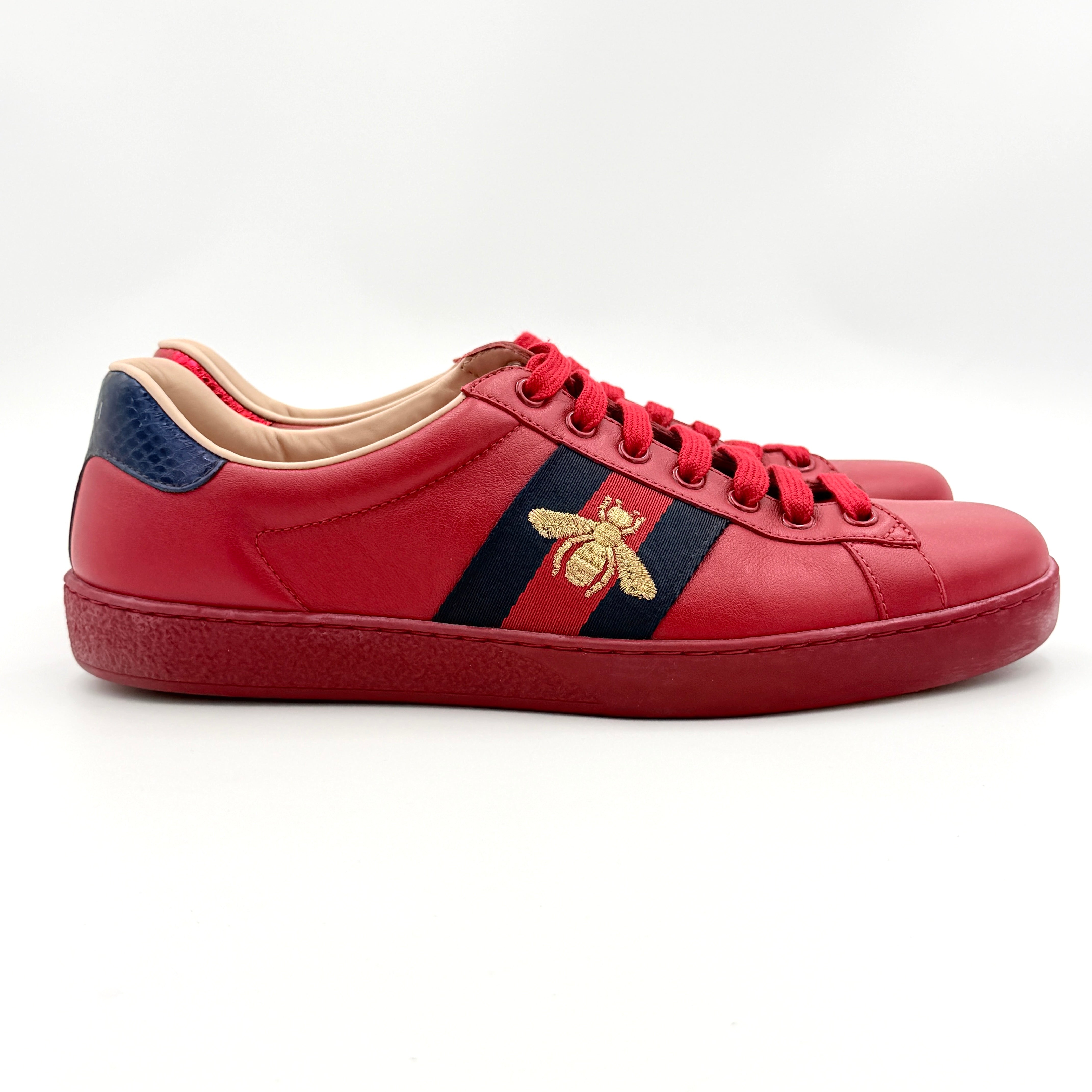 Gucci Ace Embroidered Bee sneakers in red leather with navy and red stripes and gold bee detail.