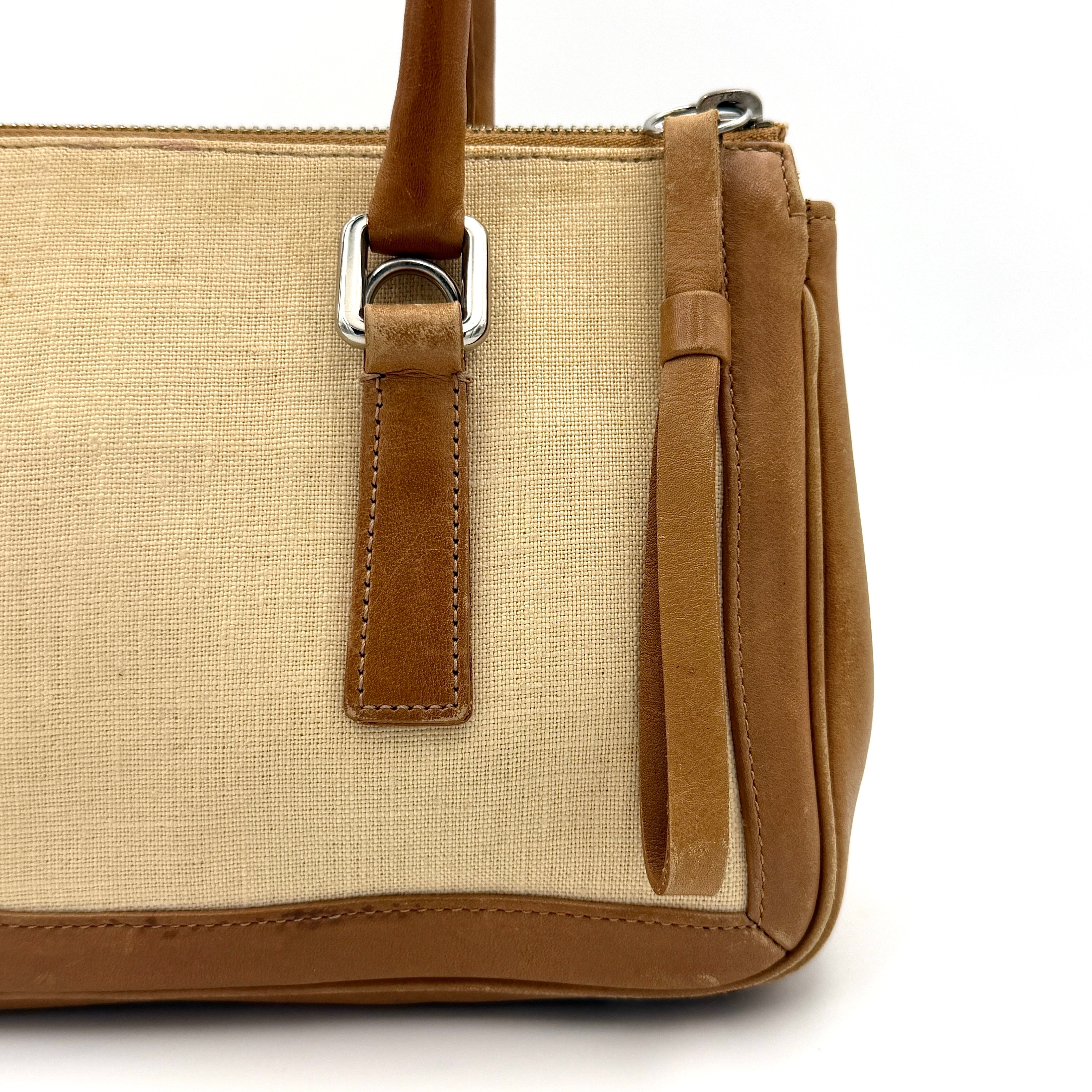 Coach Bonnie Legacy Satchel in beige canvas with caramel leather trim, structured silhouette and dual rolled handles.