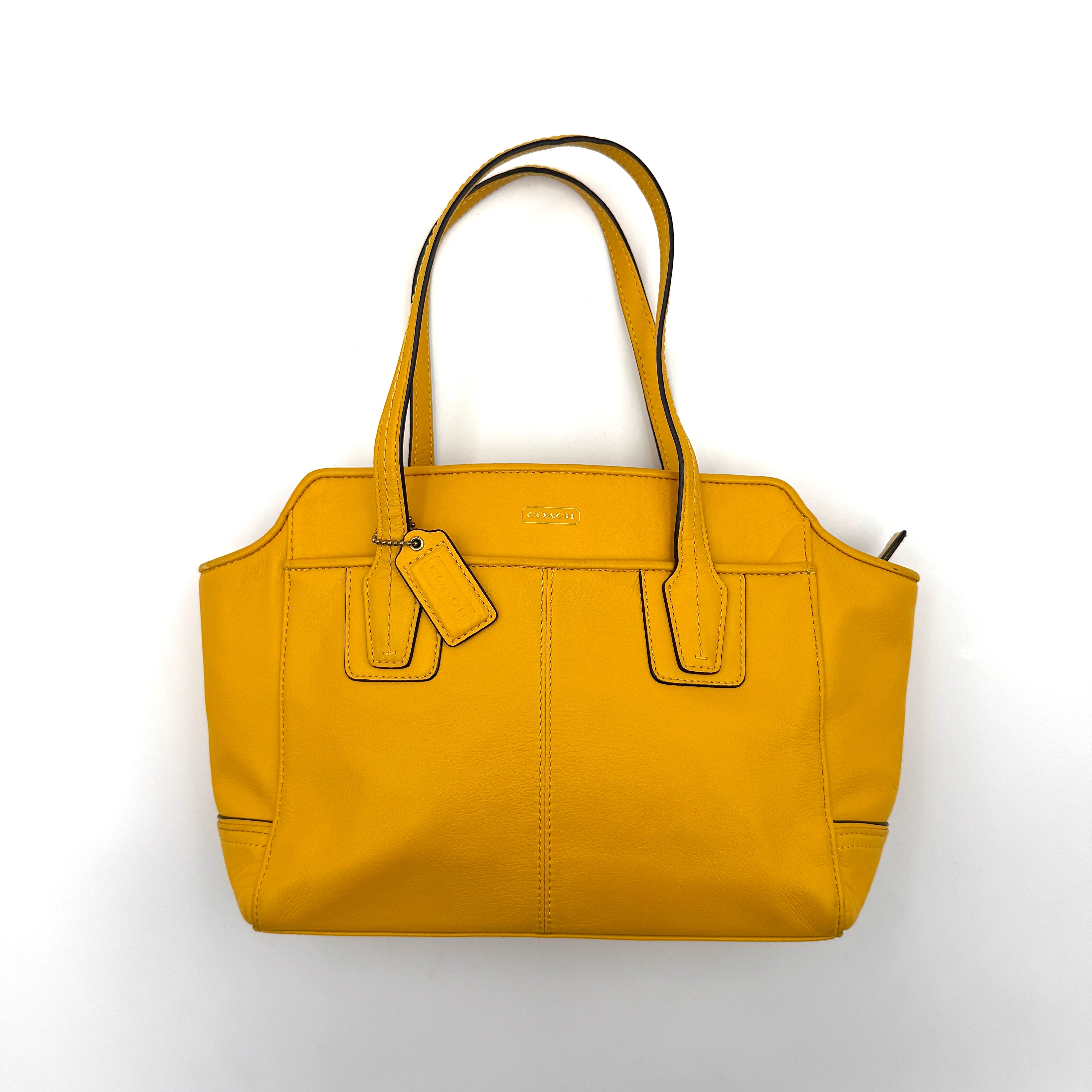 Coach Taylor Bette Mini Tote Bag in vibrant yellow leather with double top handles and detachable shoulder strap displayed beside it.