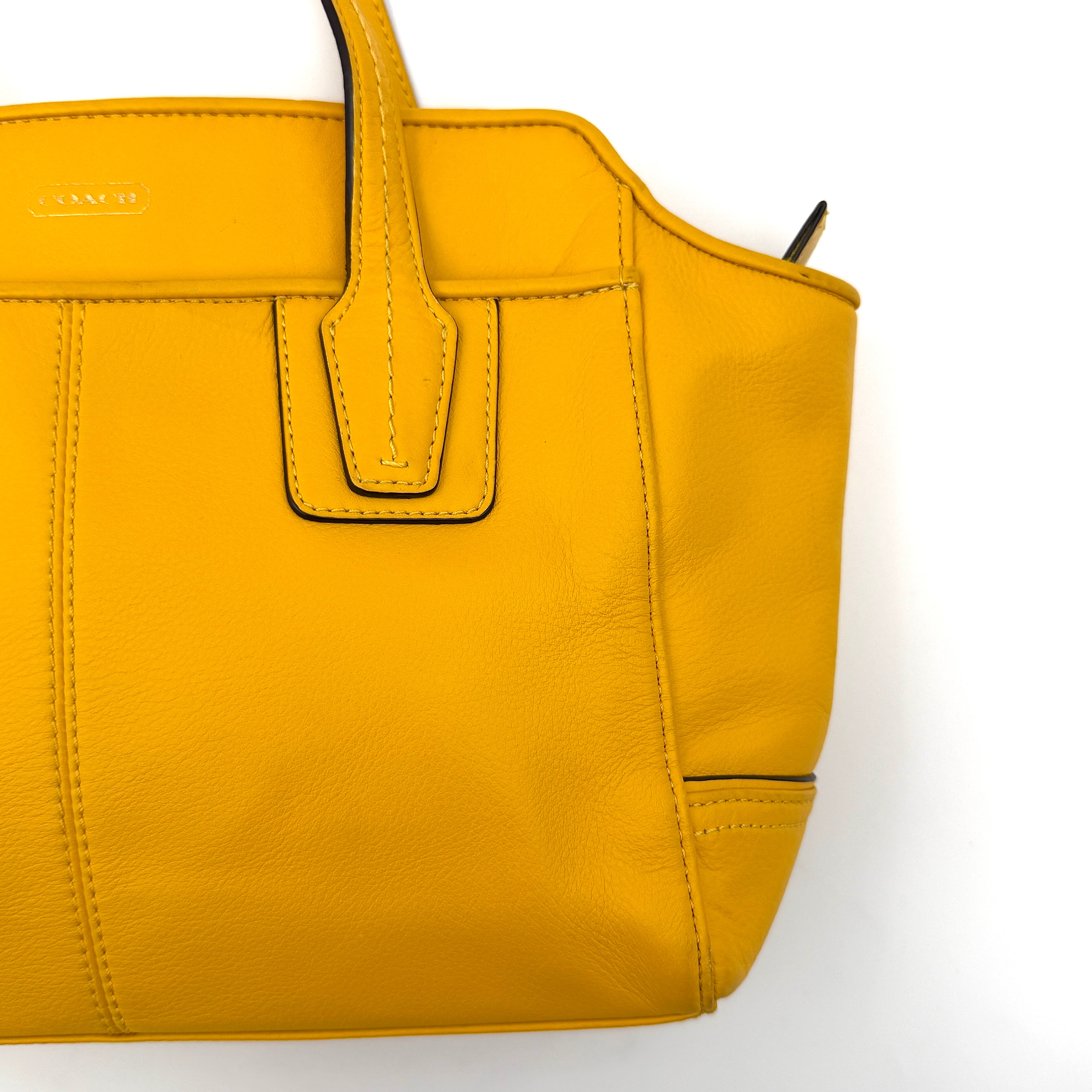 Coach Taylor Bette Mini Tote Bag in vibrant yellow leather with double top handles and detachable shoulder strap displayed beside it.