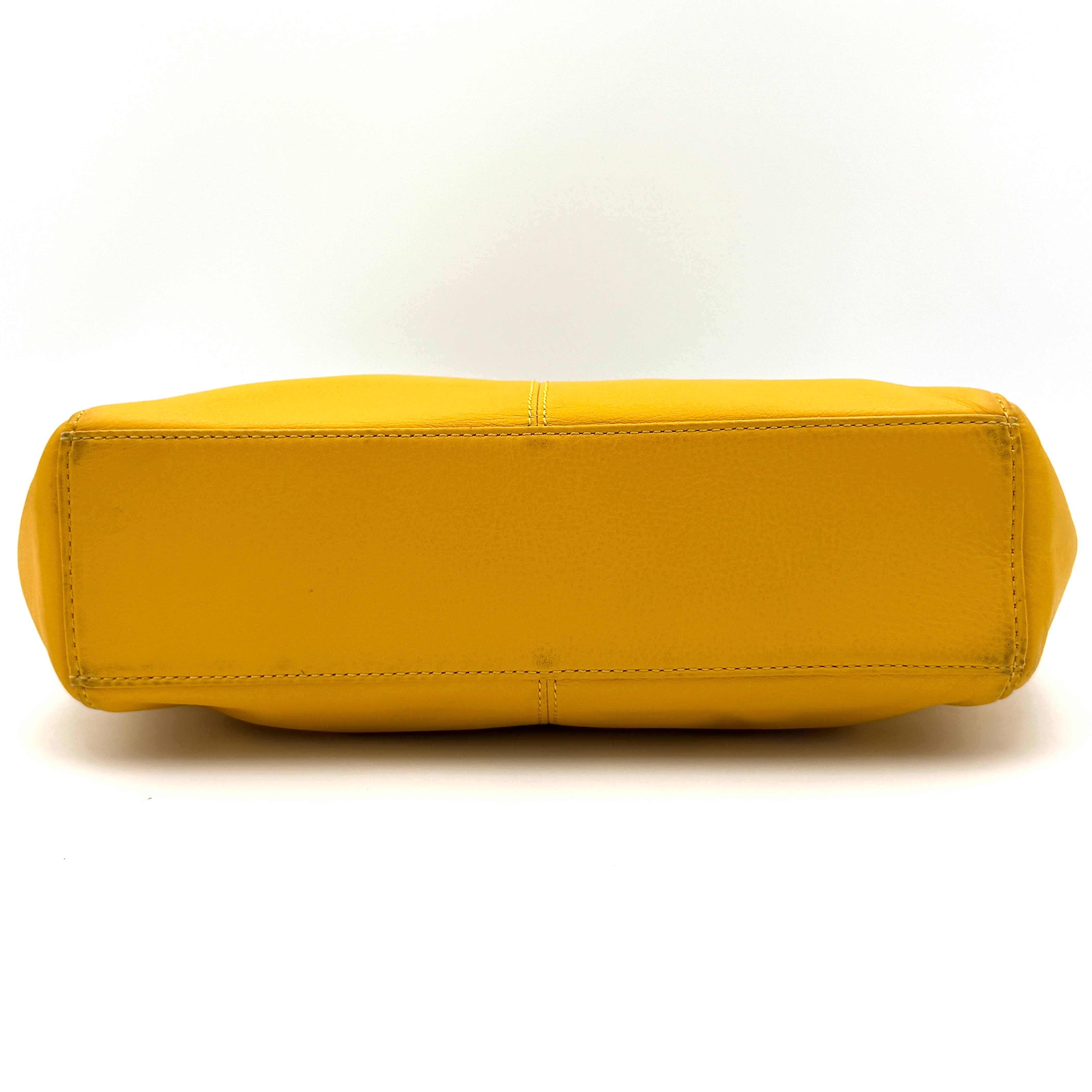 Coach Taylor Bette Mini Tote Bag in vibrant yellow leather with double top handles and detachable shoulder strap displayed beside it.