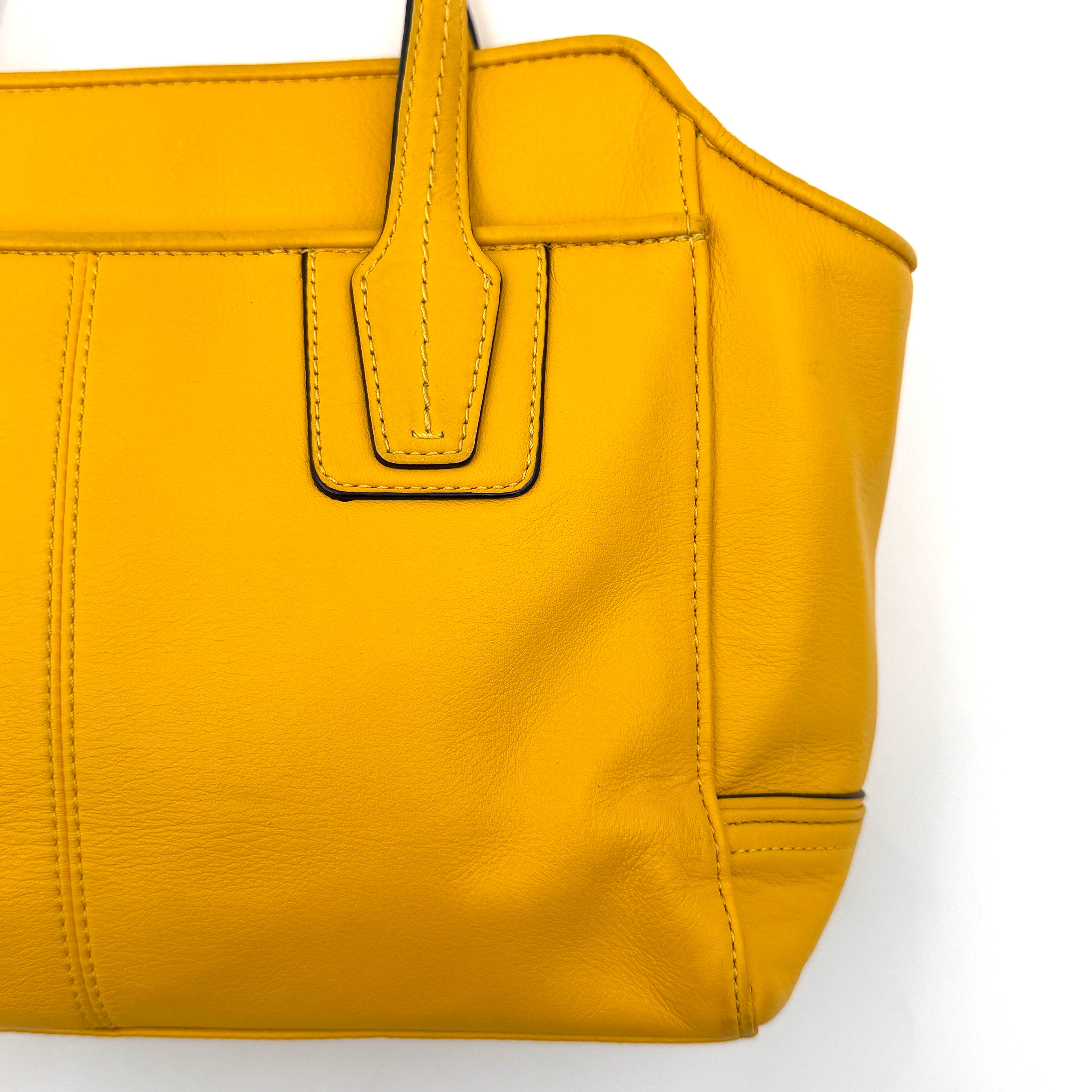 Coach Taylor Bette Mini Tote Bag in vibrant yellow leather with double top handles and detachable shoulder strap displayed beside it.