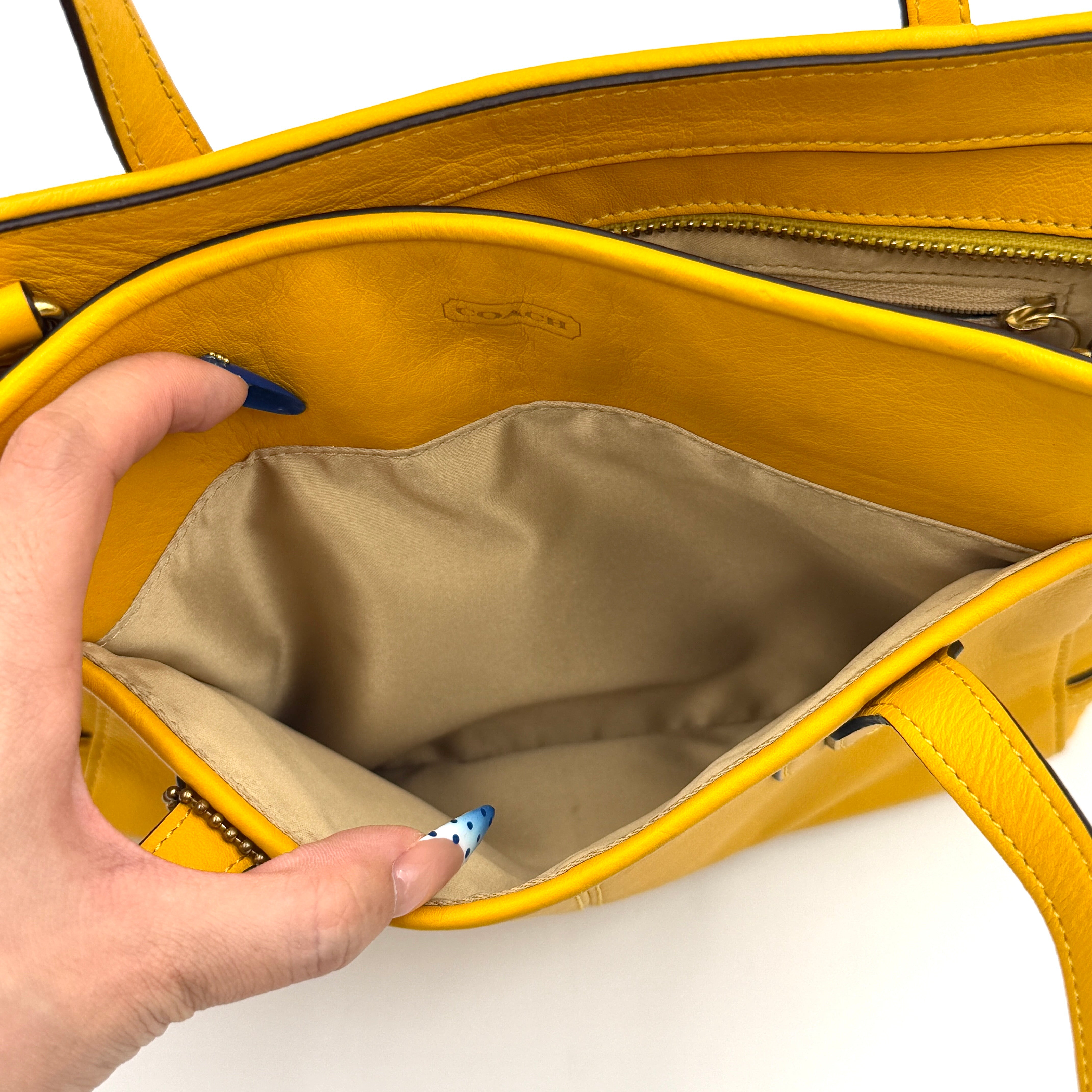 Coach Taylor Bette Mini Tote Bag in vibrant yellow leather with double top handles and detachable shoulder strap displayed beside it.