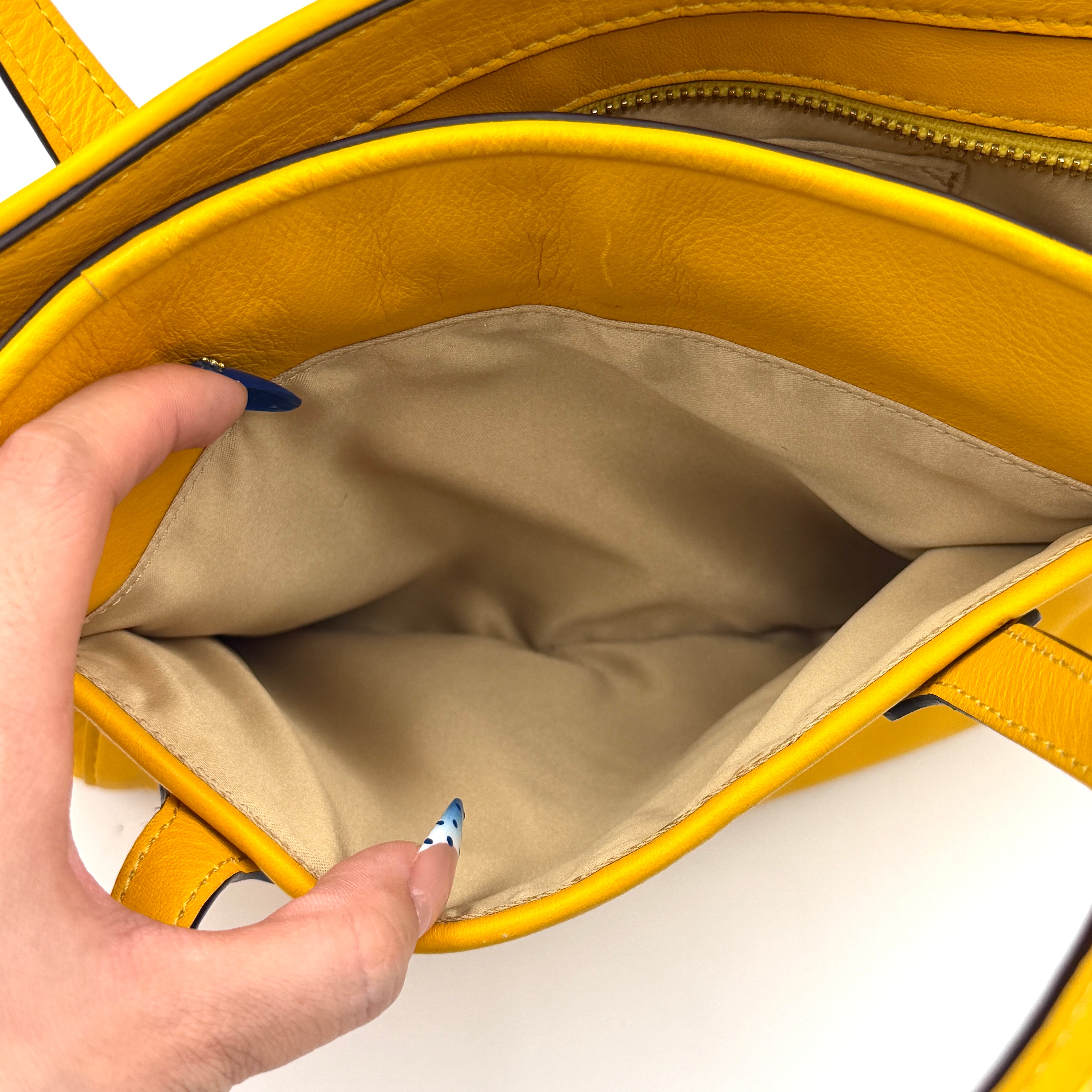 Coach Taylor Bette Mini Tote Bag in vibrant yellow leather with double top handles and detachable shoulder strap displayed beside it.