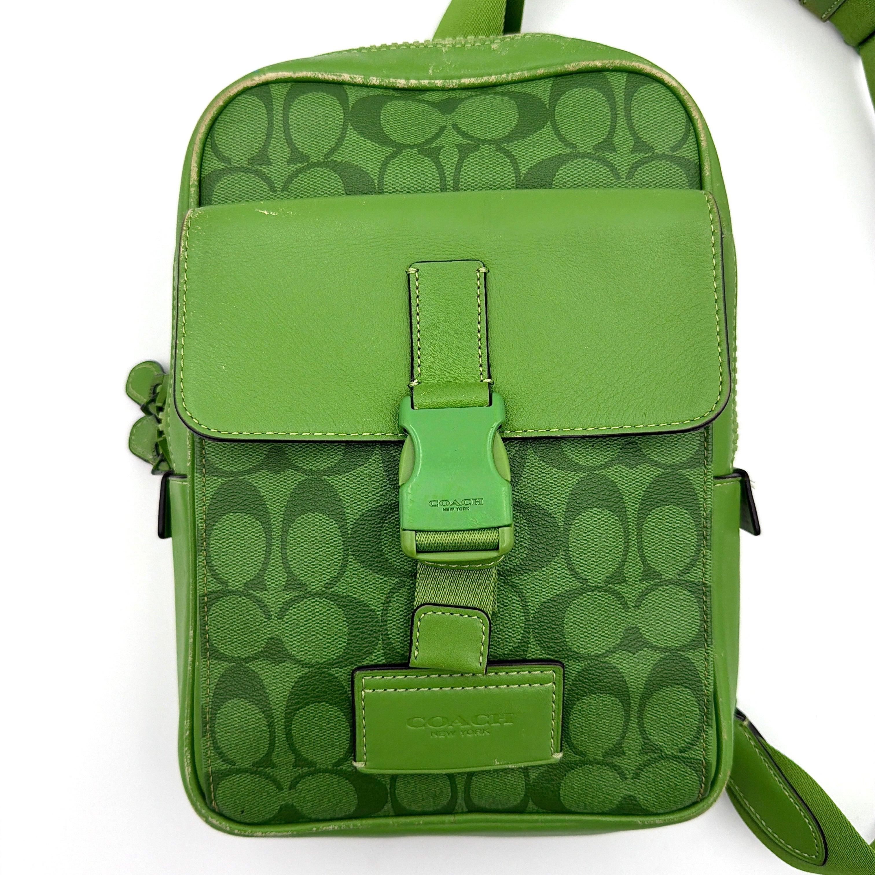 Coach Signature Canvas Track Pack Crossbody Bag in vibrant green with tonal green hardware and adjustable strap set against a clean background.