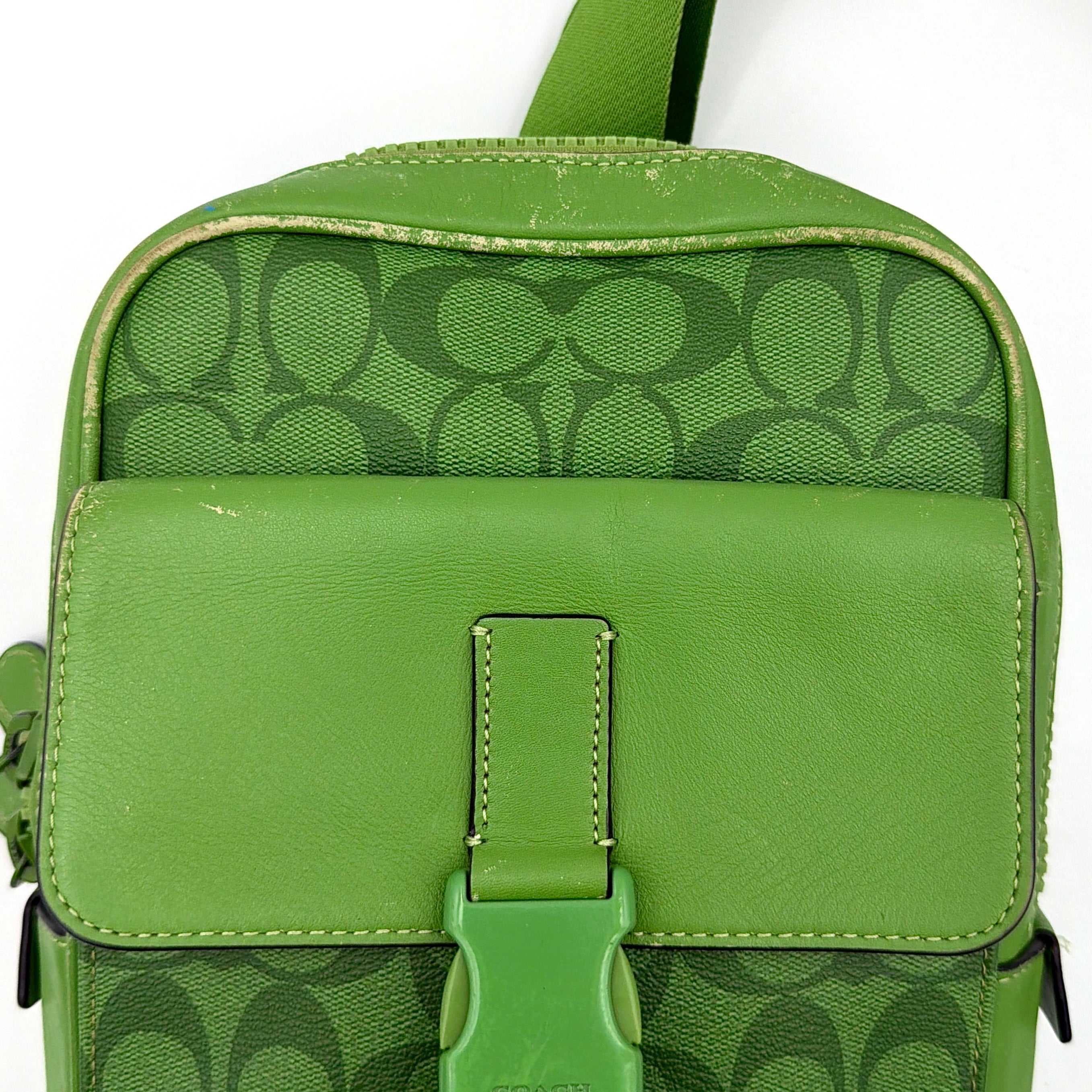 Coach Signature Canvas Track Pack Crossbody Bag in vibrant green with tonal green hardware and adjustable strap set against a clean background.