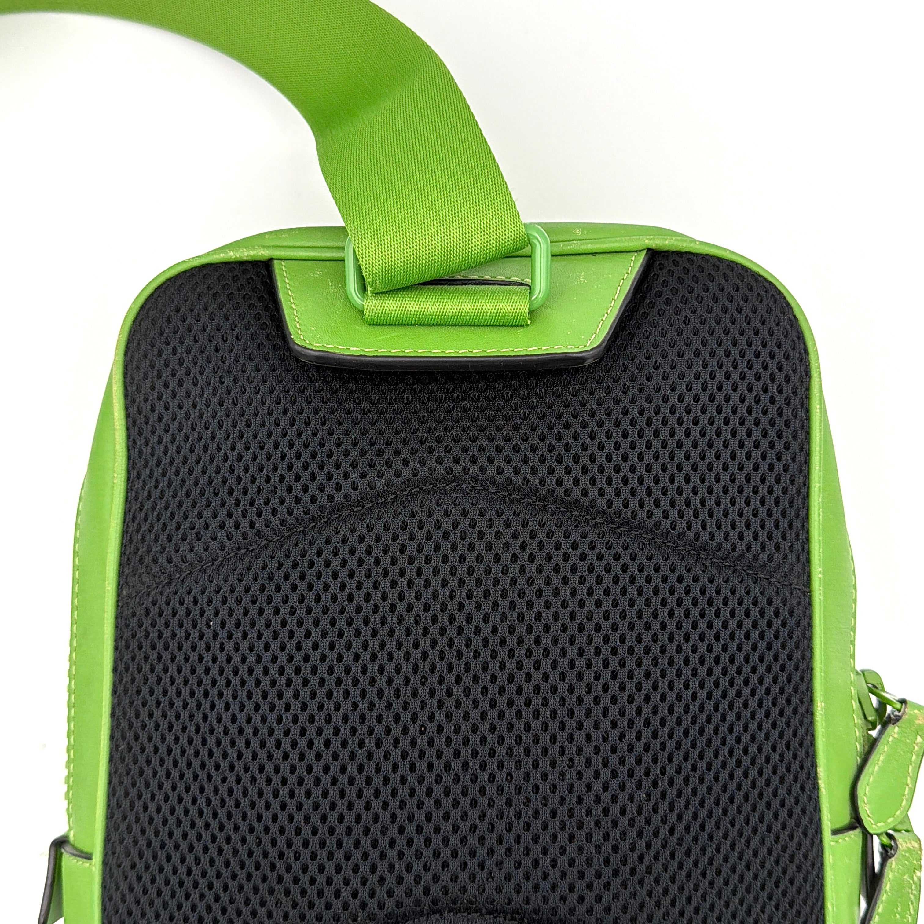 Coach Signature Canvas Track Pack Crossbody Bag in vibrant green with tonal green hardware and adjustable strap set against a clean background.