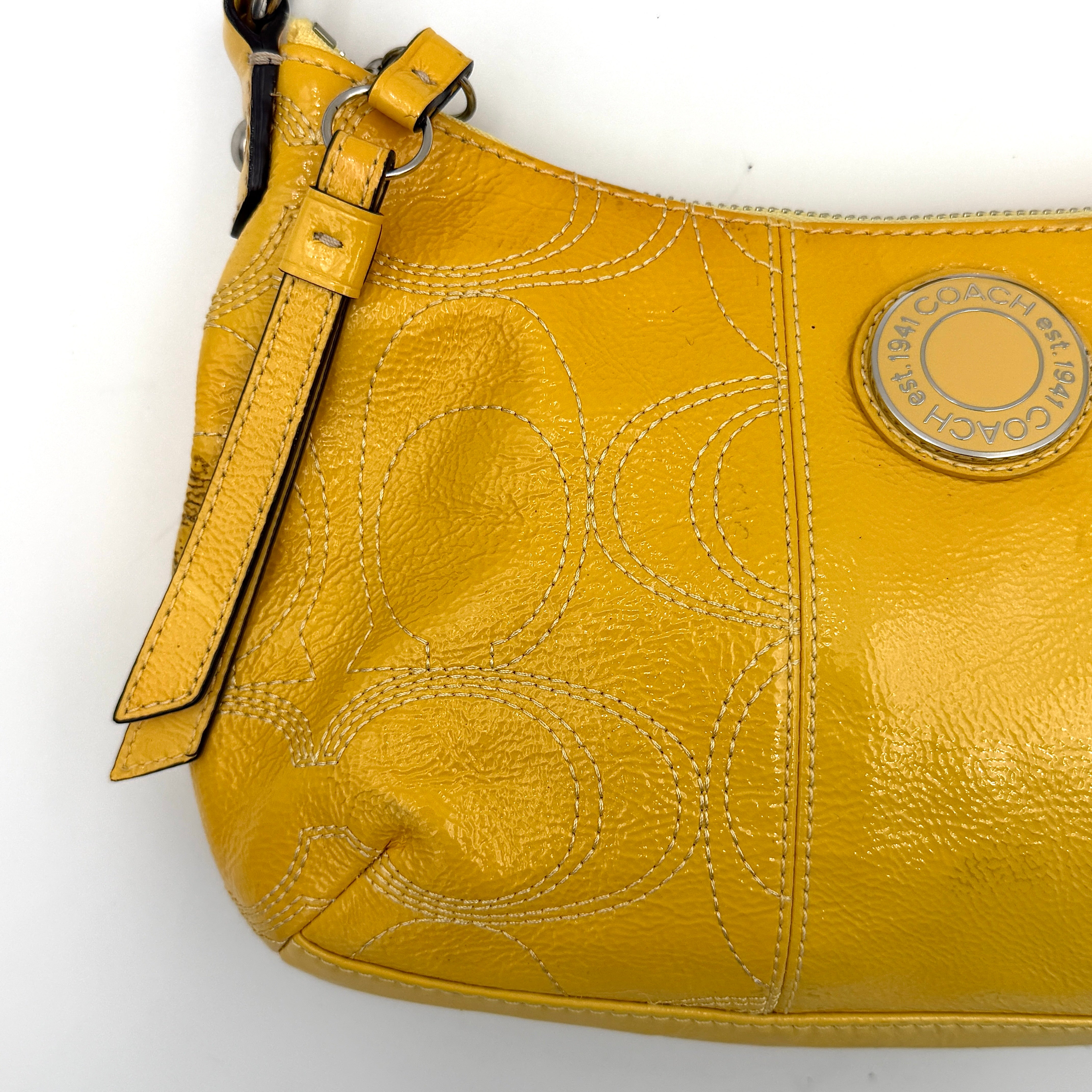 Coach 2Way Signature Stripe Patent Shoulder Bag in patent sunflower yellow leather with signature stitching and detachable strap displayed.
