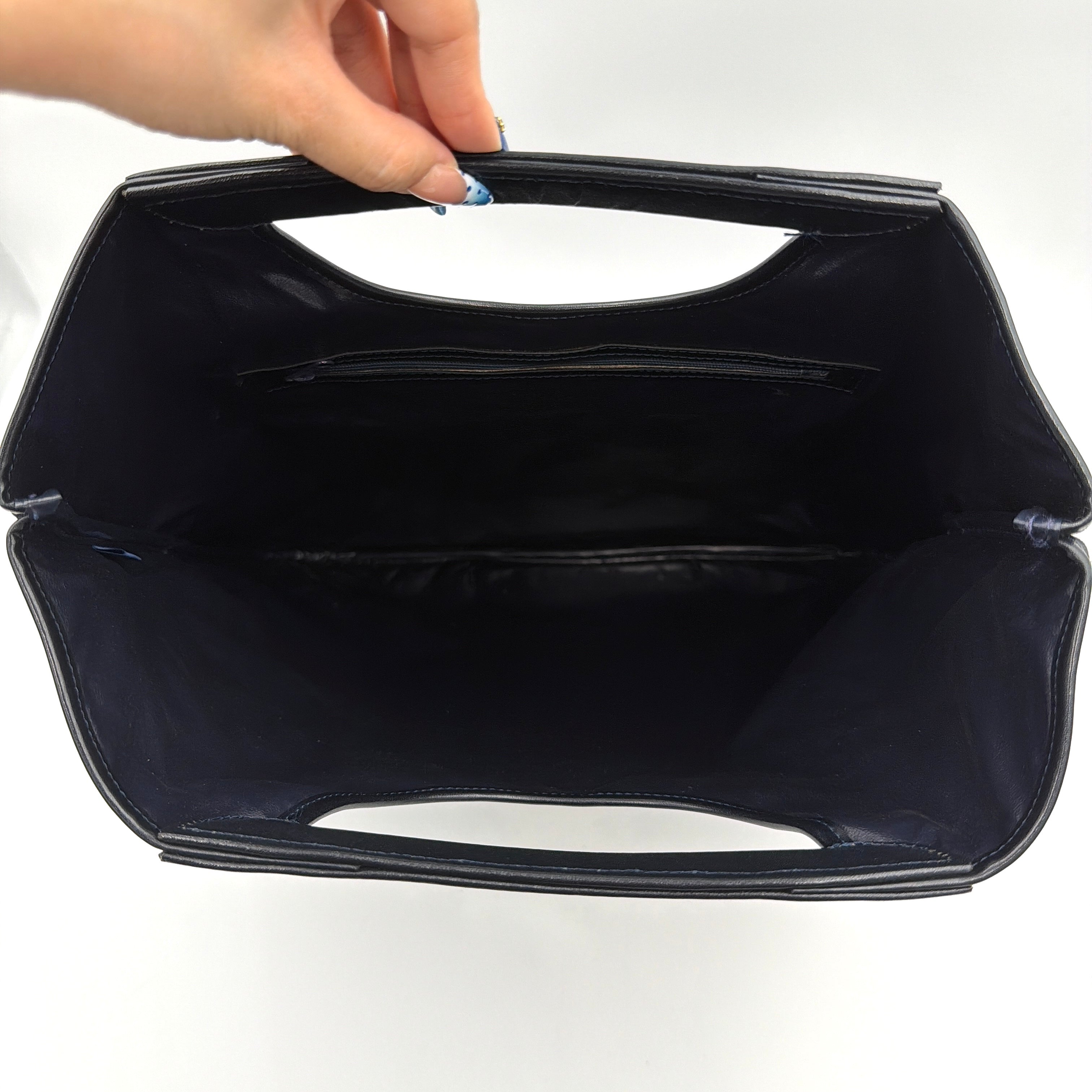 Celine Noevir Macadam Foldover Tote in navy jacquard with carriage motif, leather trim and cutout handles, photographed against a white background.