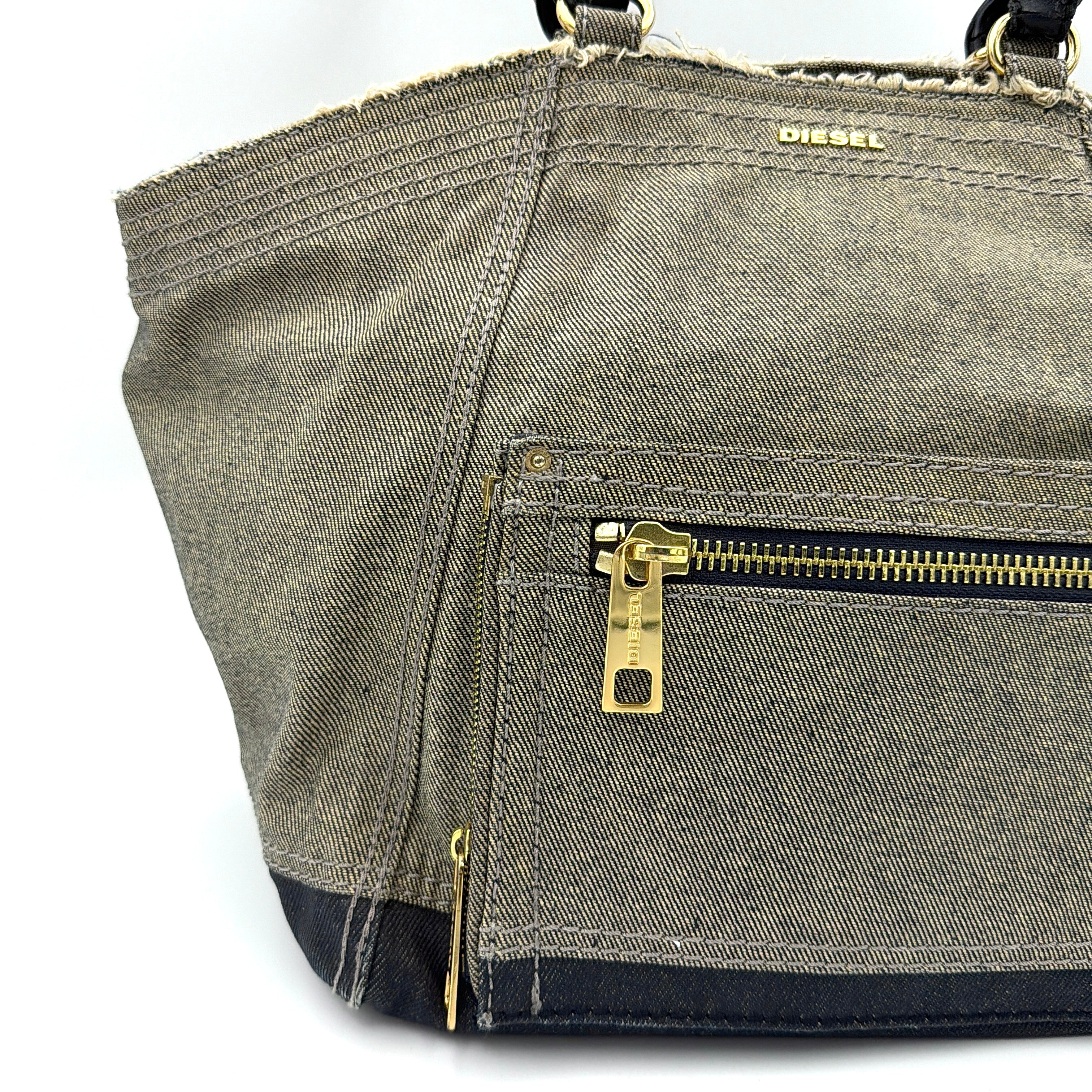 Diesel washed denim shoulder bag with black leather handles, gold zips and frayed edge detail.