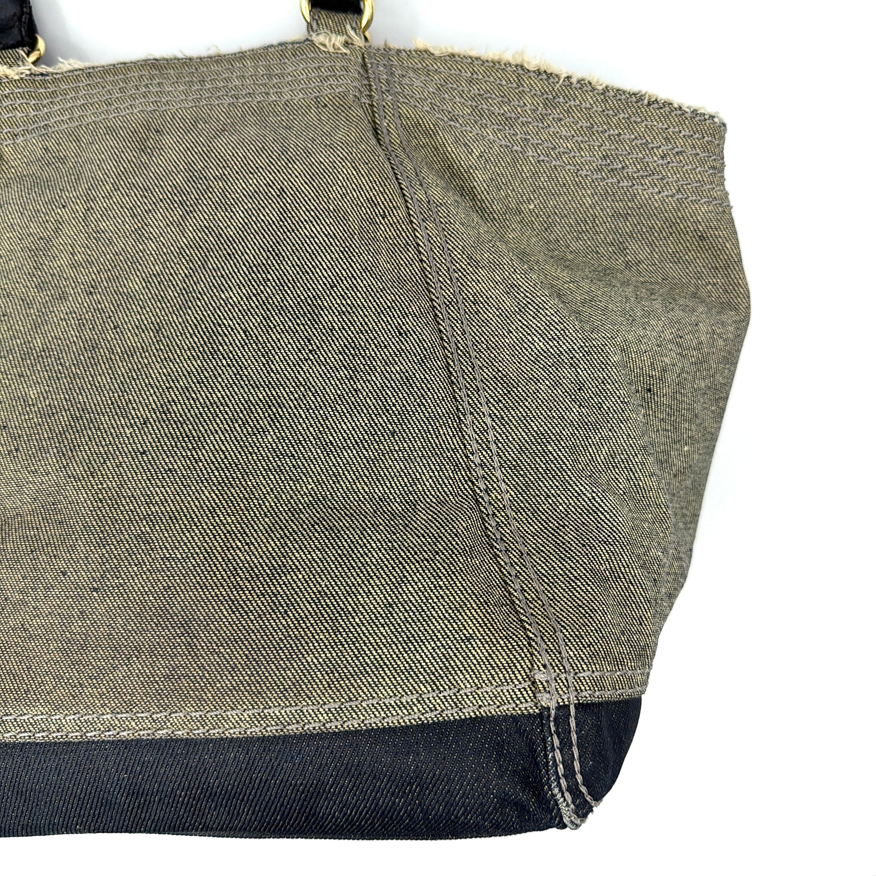Diesel washed denim shoulder bag with black leather handles, gold zips and frayed edge detail.