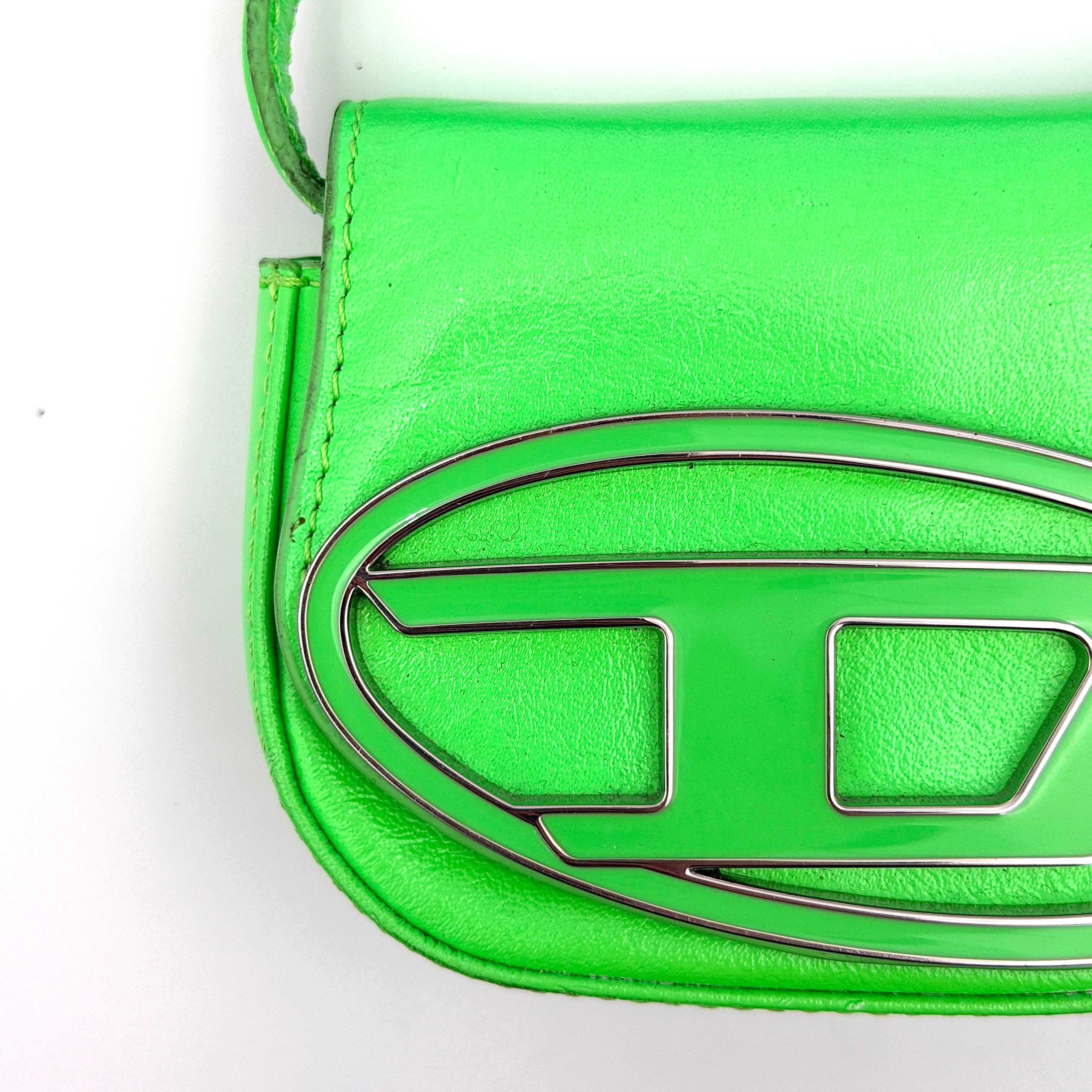 Diesel 1DR-XS Mini Bag in vivid neon green leather with bold silver D plaque and detachable strap, presented against a clean background.