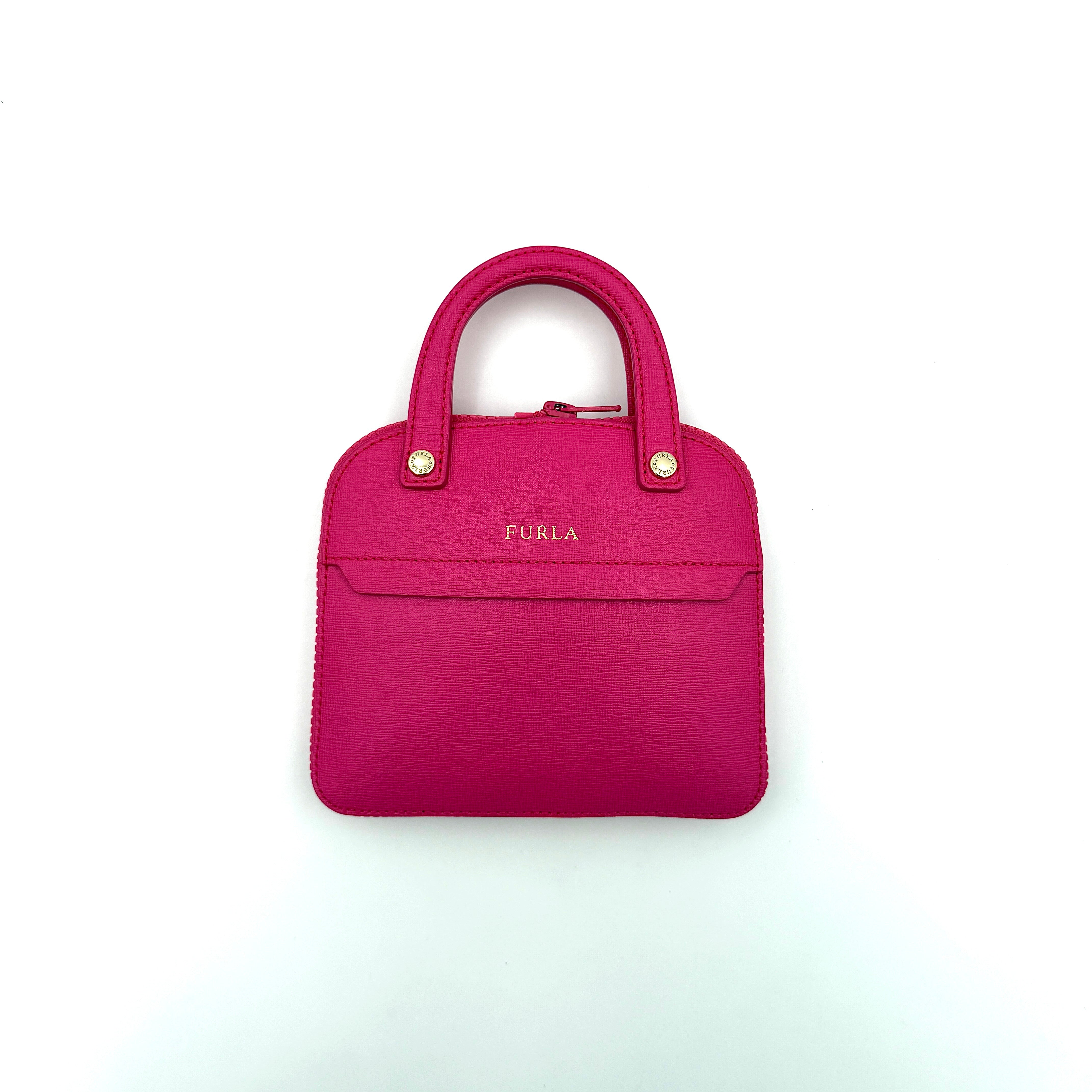 Furla black nylon tote bag with a bold pink zip pouch detail, styled as an exterior pocket, displayed flat to showcase its silhouette.