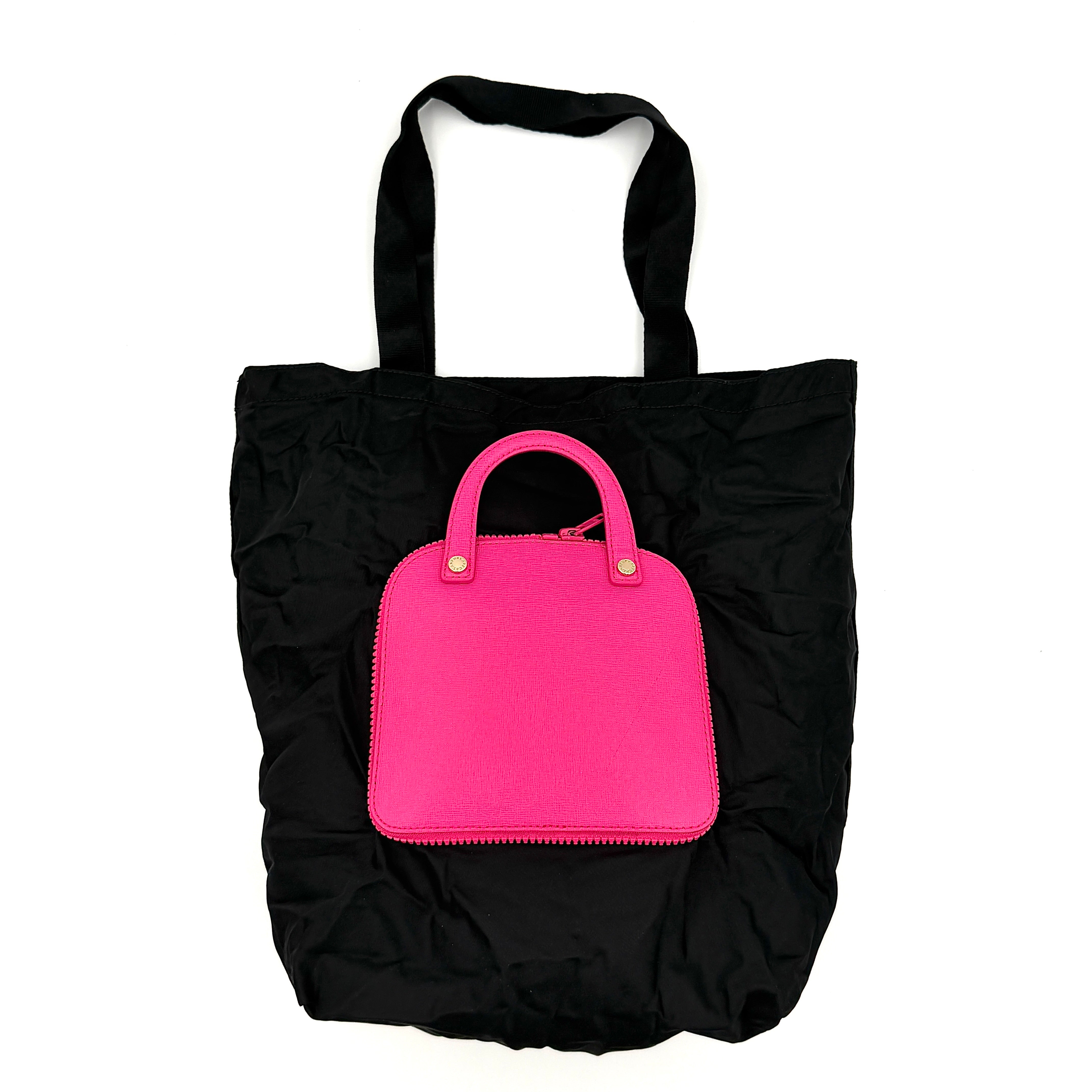 Furla black nylon tote bag with a bold pink zip pouch detail, styled as an exterior pocket, displayed flat to showcase its silhouette.
