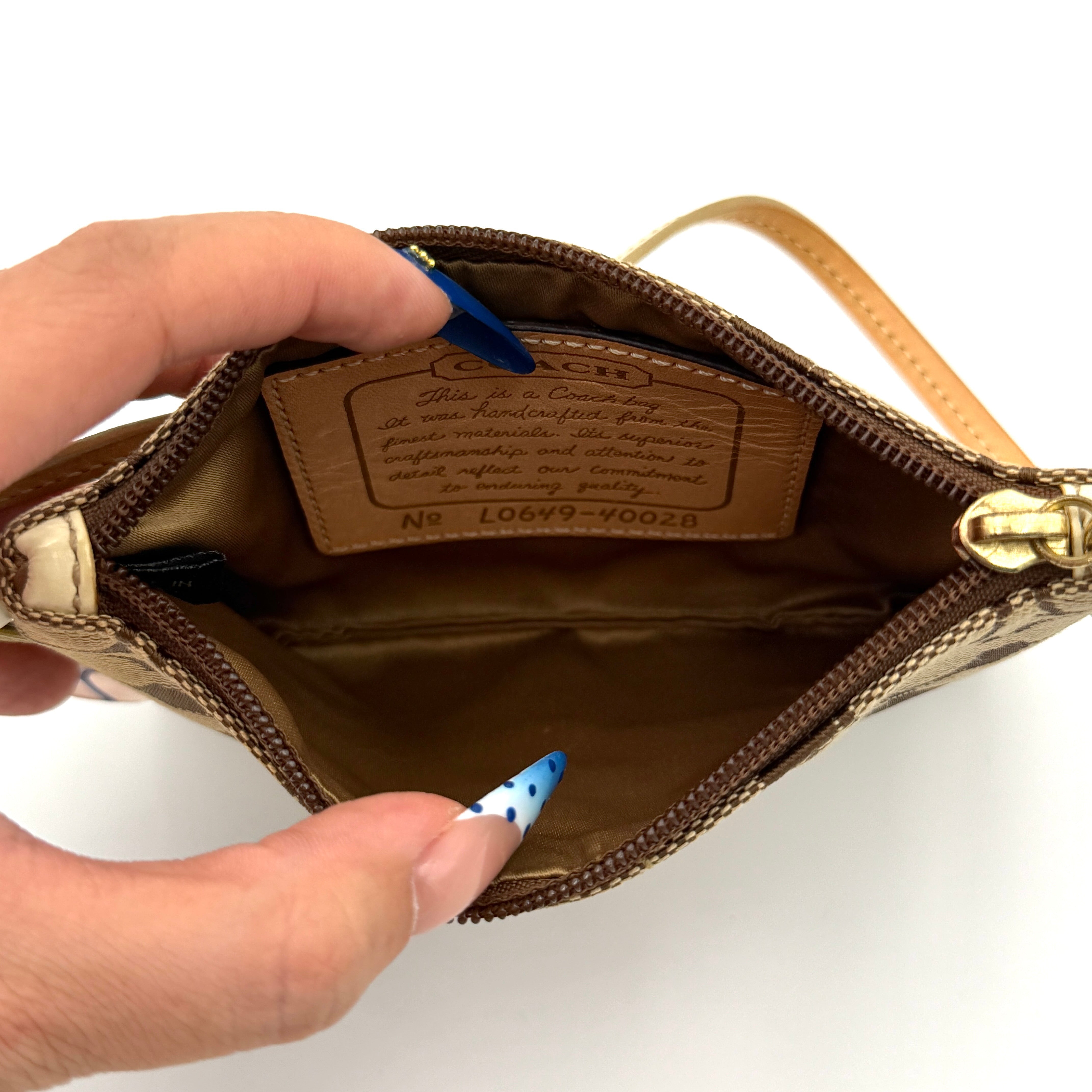 Coach Signature Stripe Wristlet in beige and cream jacquard, accented with a cream leather strap and gold-tone hardware.