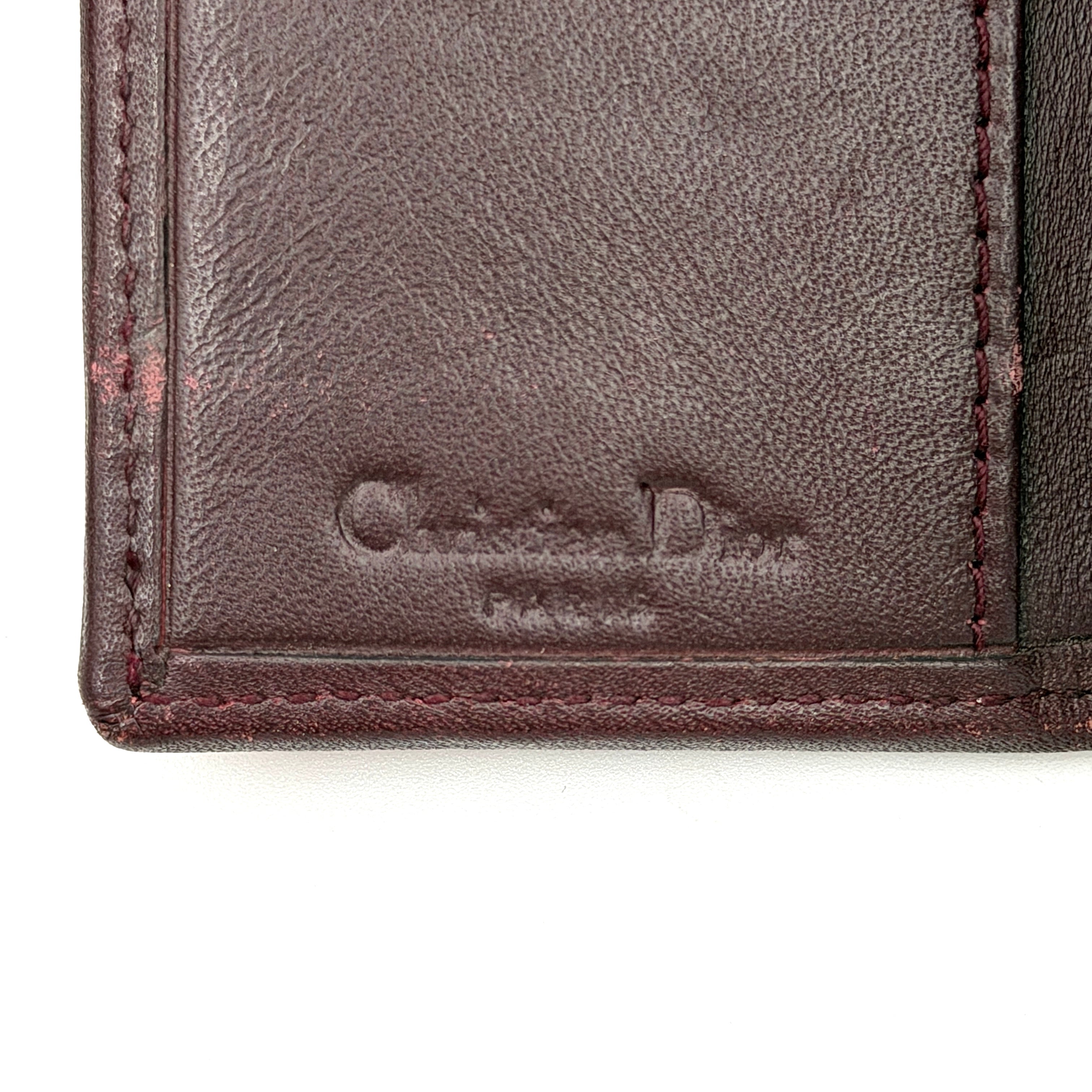 Dior Trotter Monogram key holder in red canvas with burgundy leather trim, photographed closed on a clean white background.