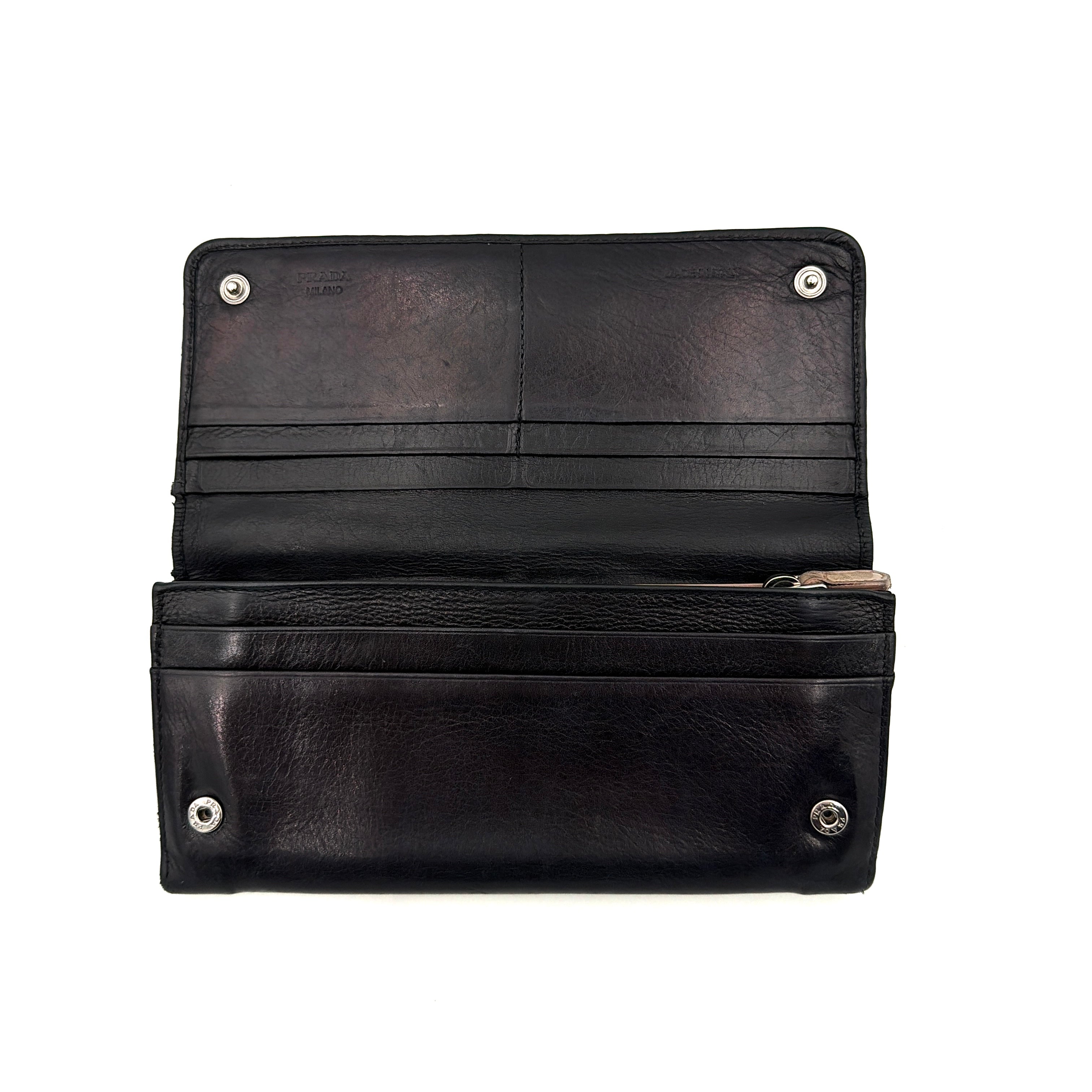 Prada Fiocco Bow Continental Wallet in black leather with a central grosgrain bow and silver-tone accents, displayed with refined simplicity.