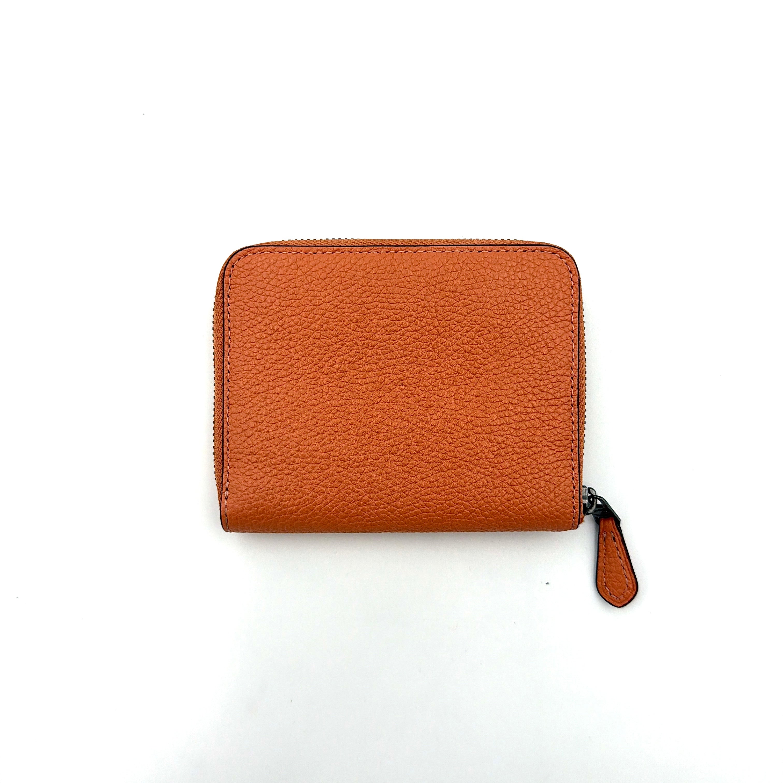 Coach Prairie Rivets Zip Around Small Wallet in orange pebbled leather with floral rivets and zip-around closure.