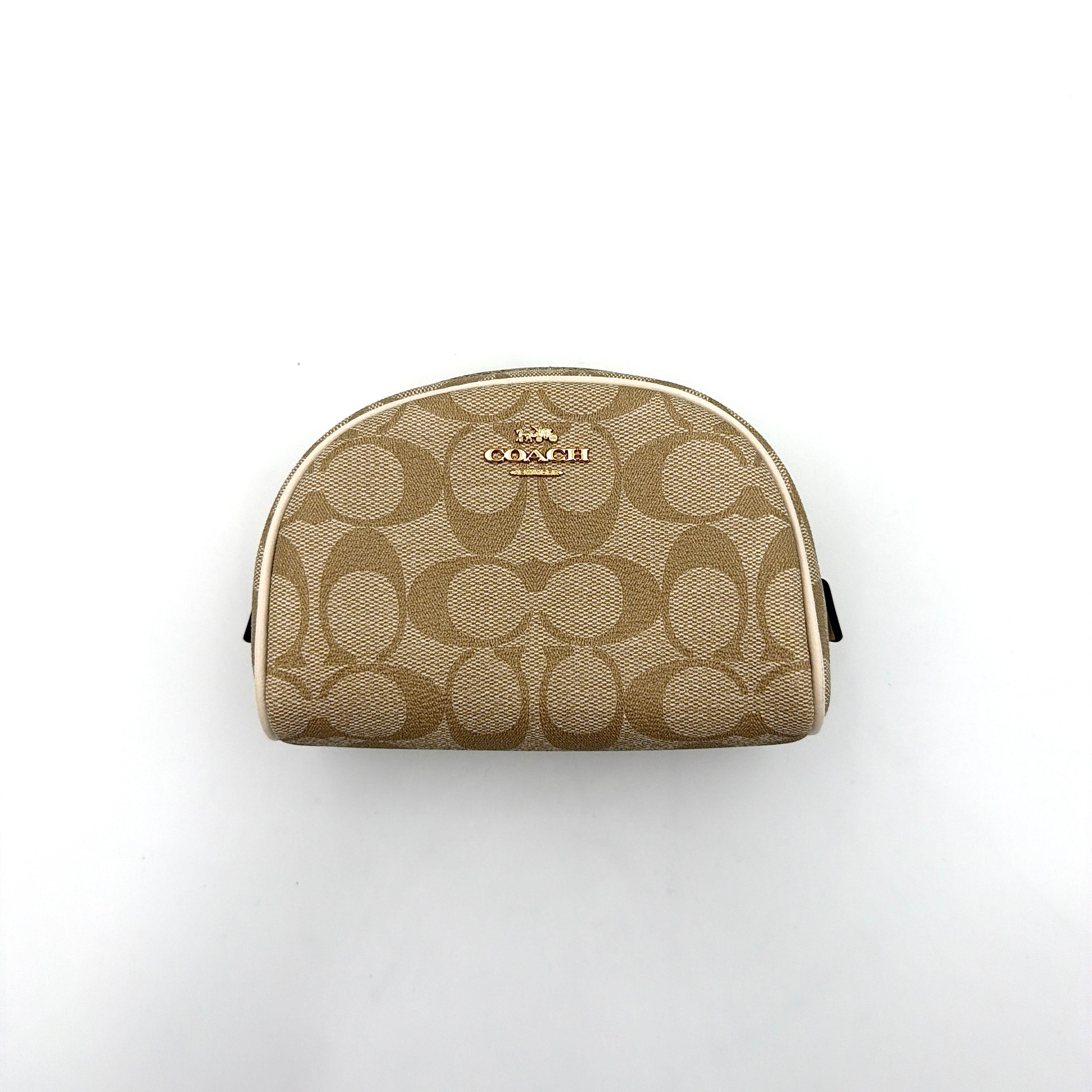 Coach Signature Canvas Dome Cosmetic Case in beige monogram canvas with gold hardware and curved silhouette.