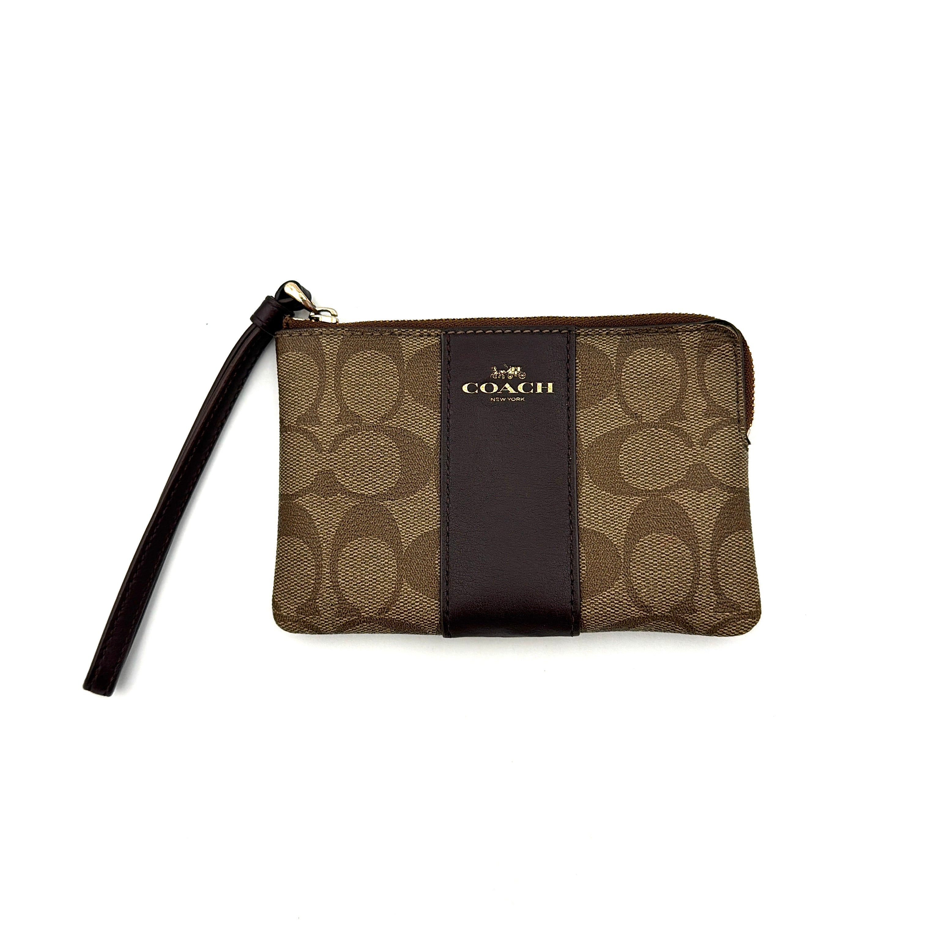 Coach Signature Stripe Corner Zip Wristlet in beige and brown canvas with a dark brown leather stripe and gold logo, shown with wristlet strap.