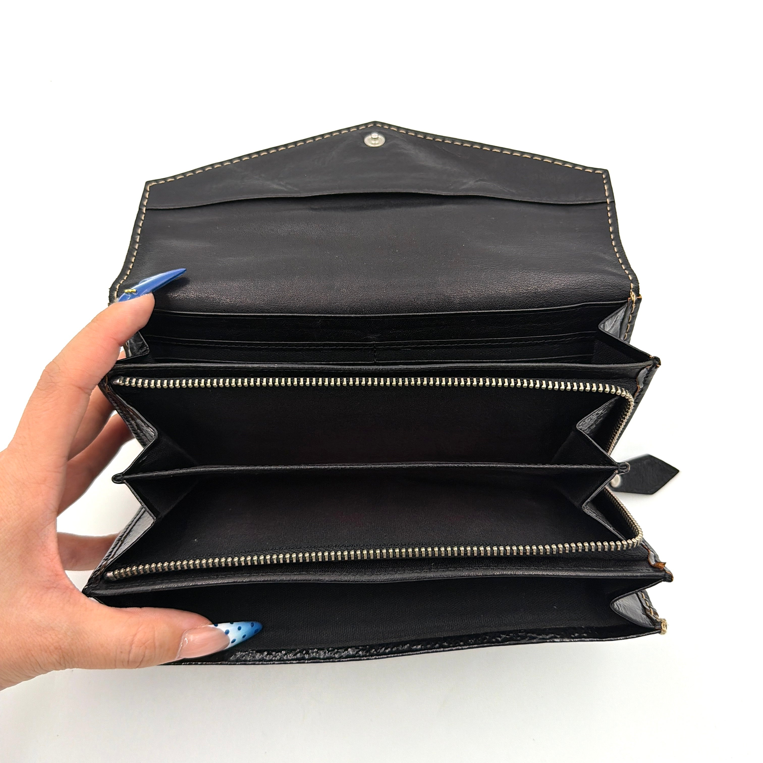 Vivienne Westwood black patent wallet featuring a silver heart orb emblem and envelope flap design.