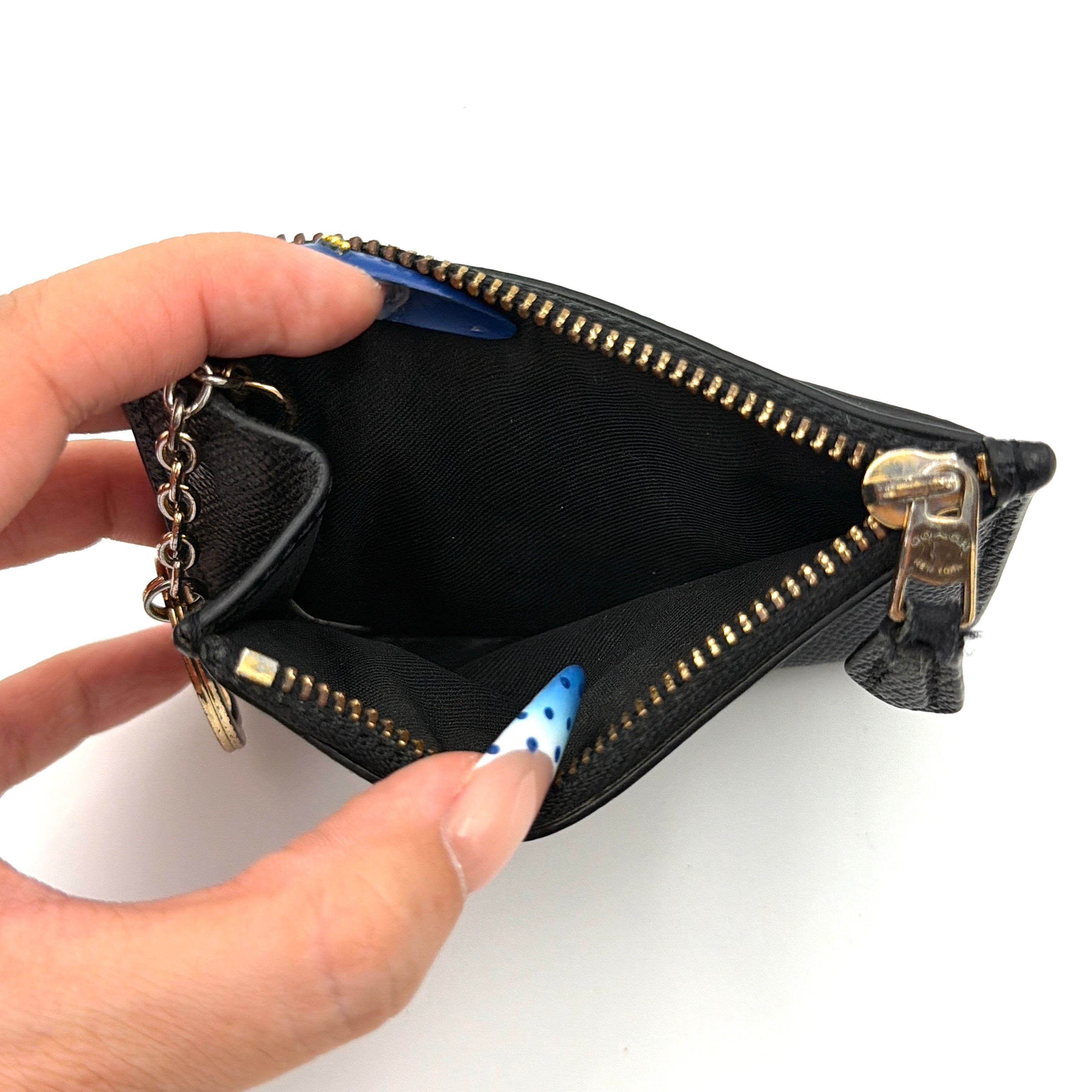 Coach Mini Skinny ID Case Cardholder in black leather with gold-tone hardware, featuring a zip closure and signature logo detailing.