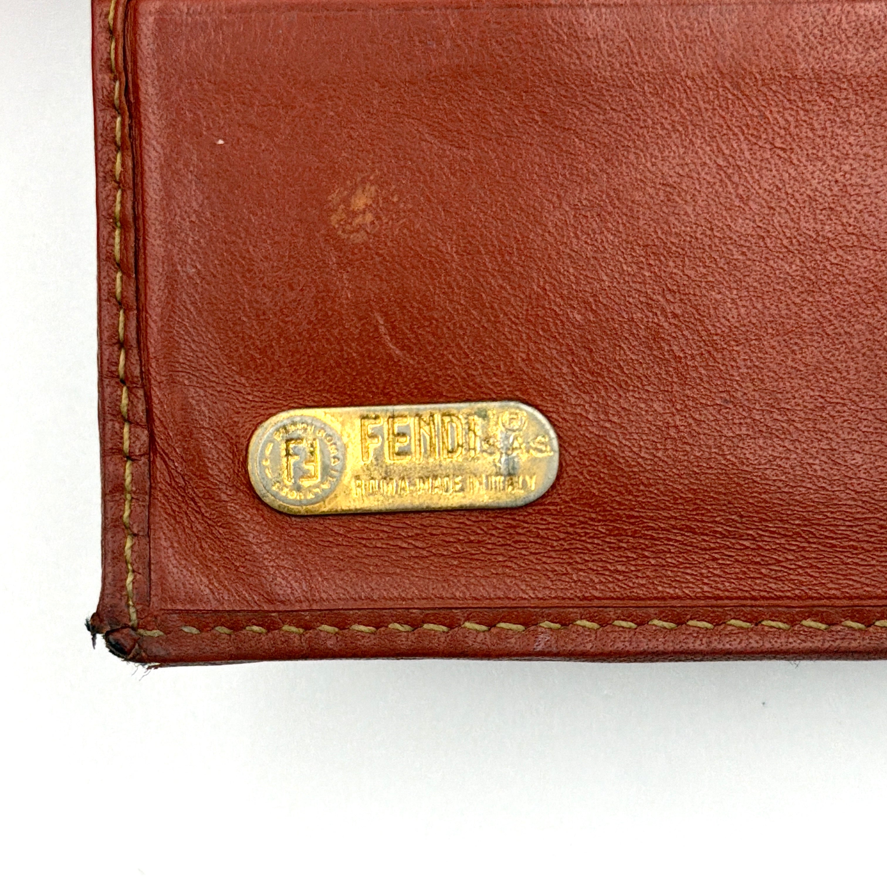 Fendi Pequin Stripe wallet in brown and black canvas with cognac leather trim and circular Fendi badge on the front.