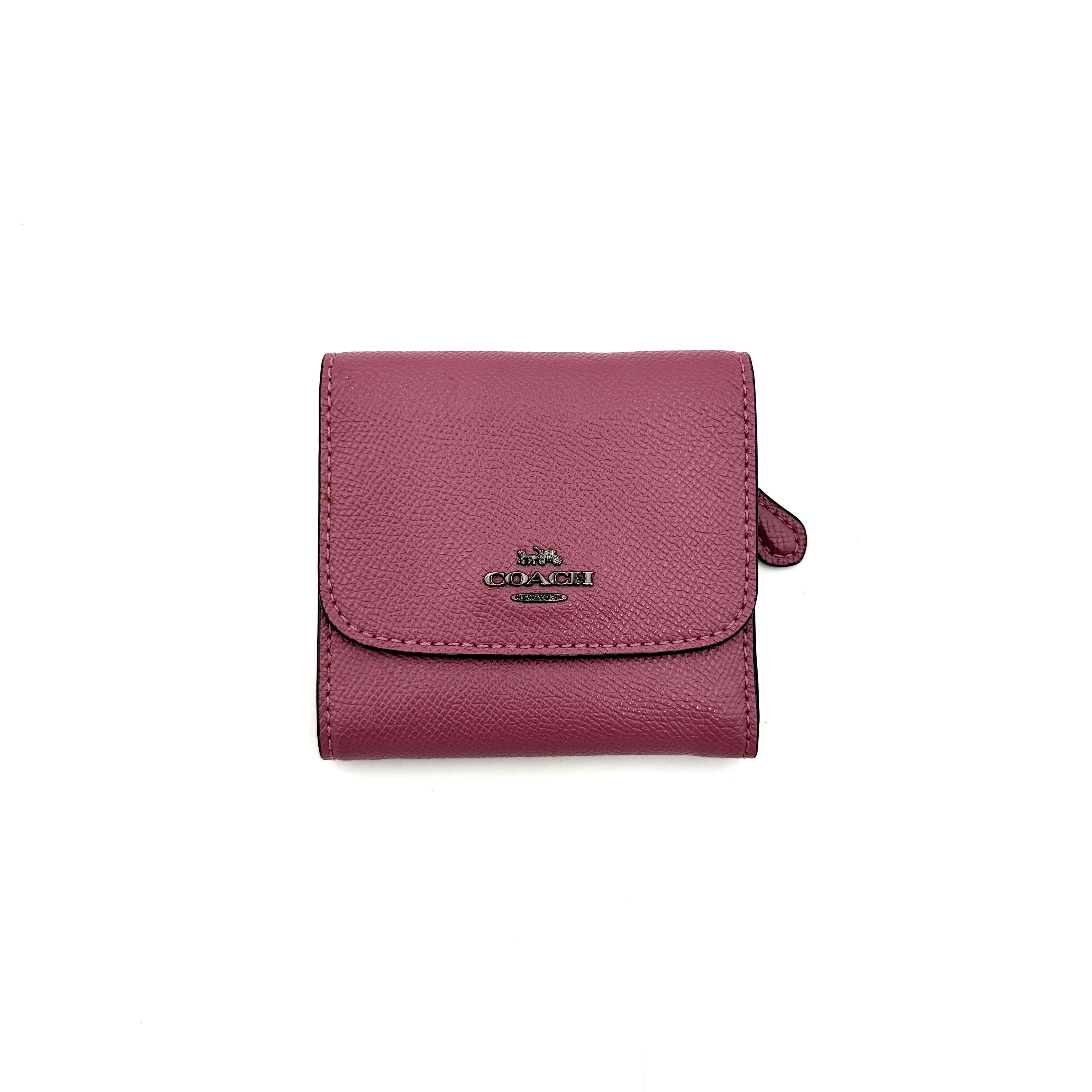 Coach small wallet in pink pebbled leather with silver logo hardware, presented closed and front-facing.