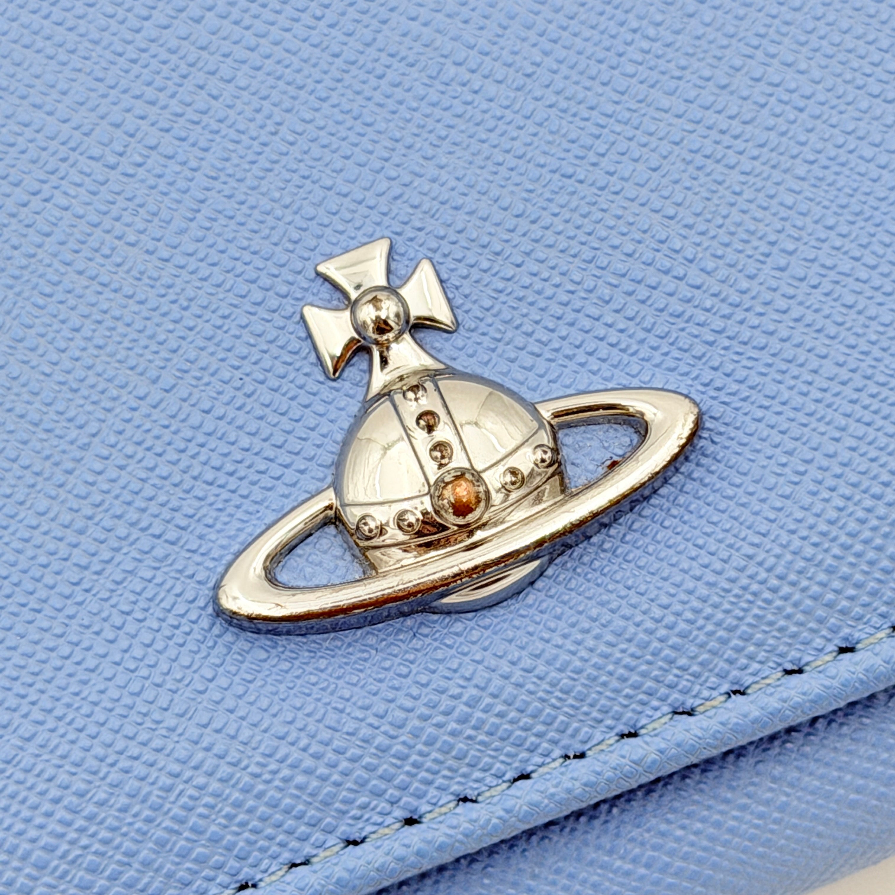 A baby blue leather Vivienne Westwood wallet with silver Orb logo and structured silhouette, photographed against a clean background.
