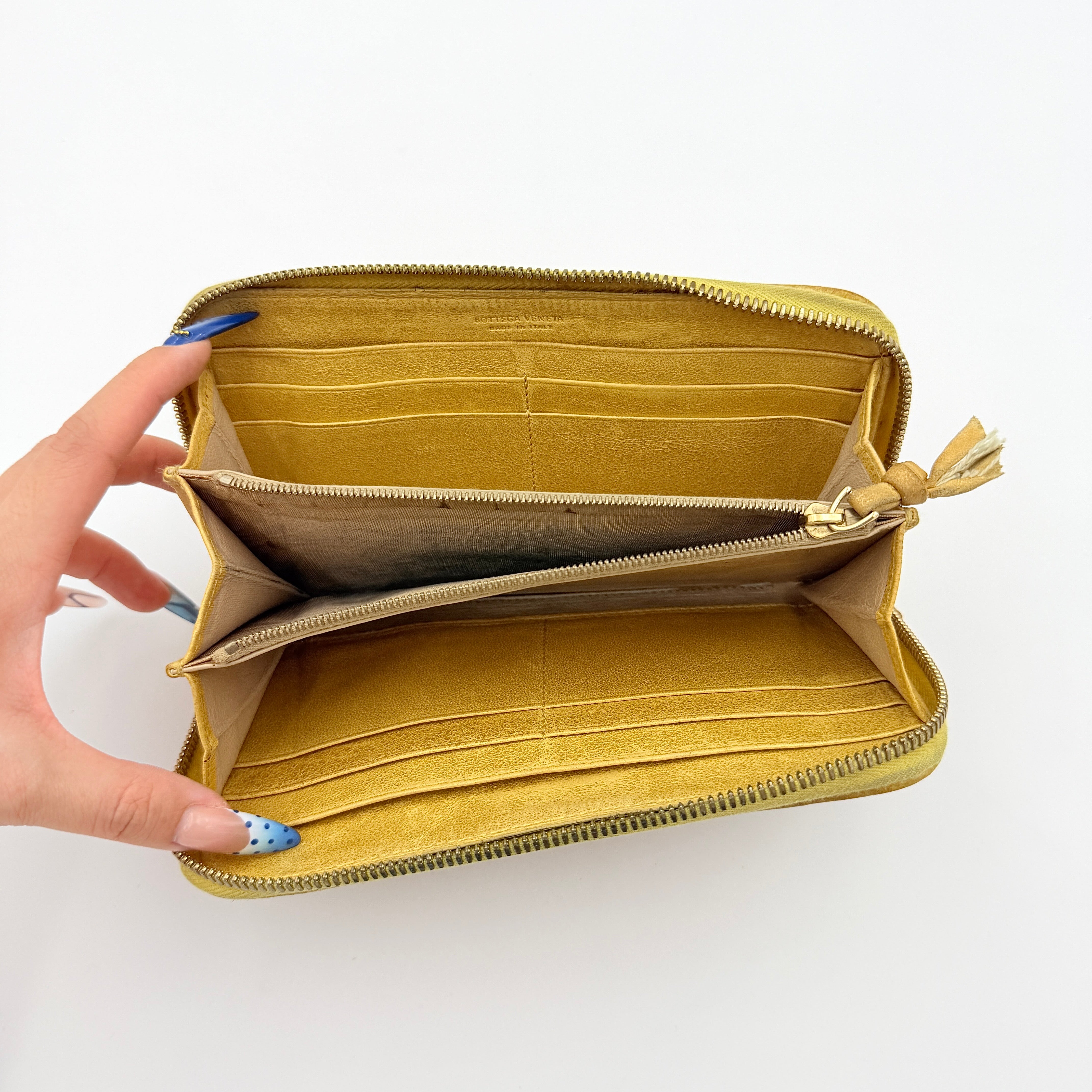 Bottega Veneta yellow Intrecciato woven leather long wallet with gold zip-around closure and signature leather pull.