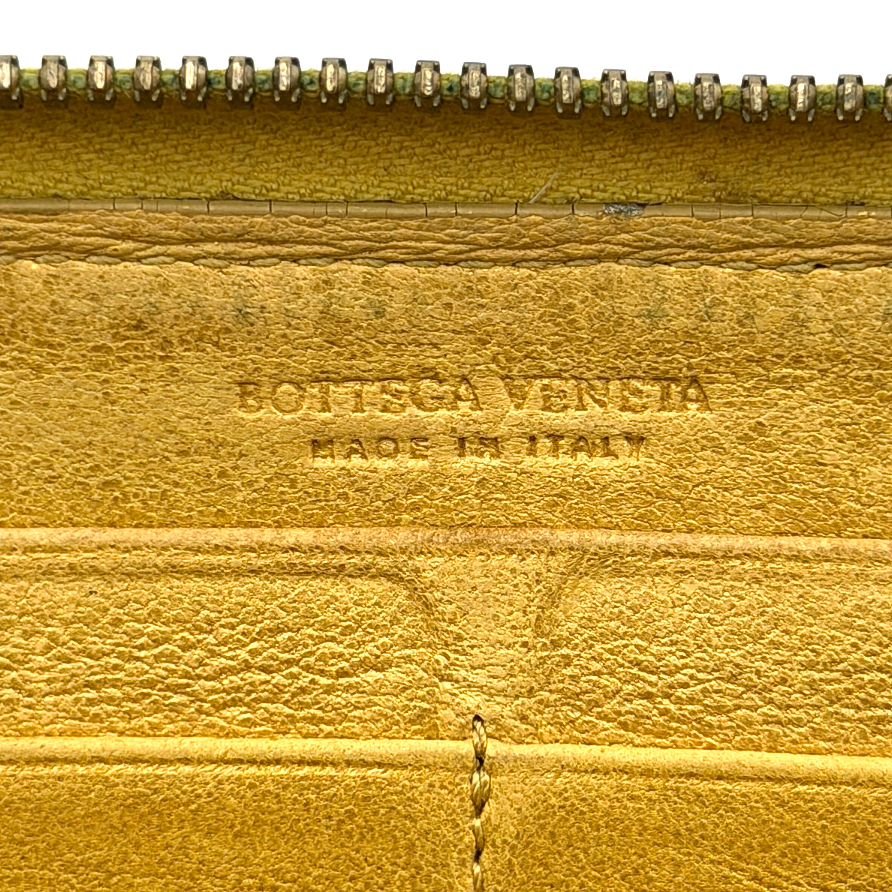 Bottega Veneta yellow Intrecciato woven leather long wallet with gold zip-around closure and signature leather pull.
