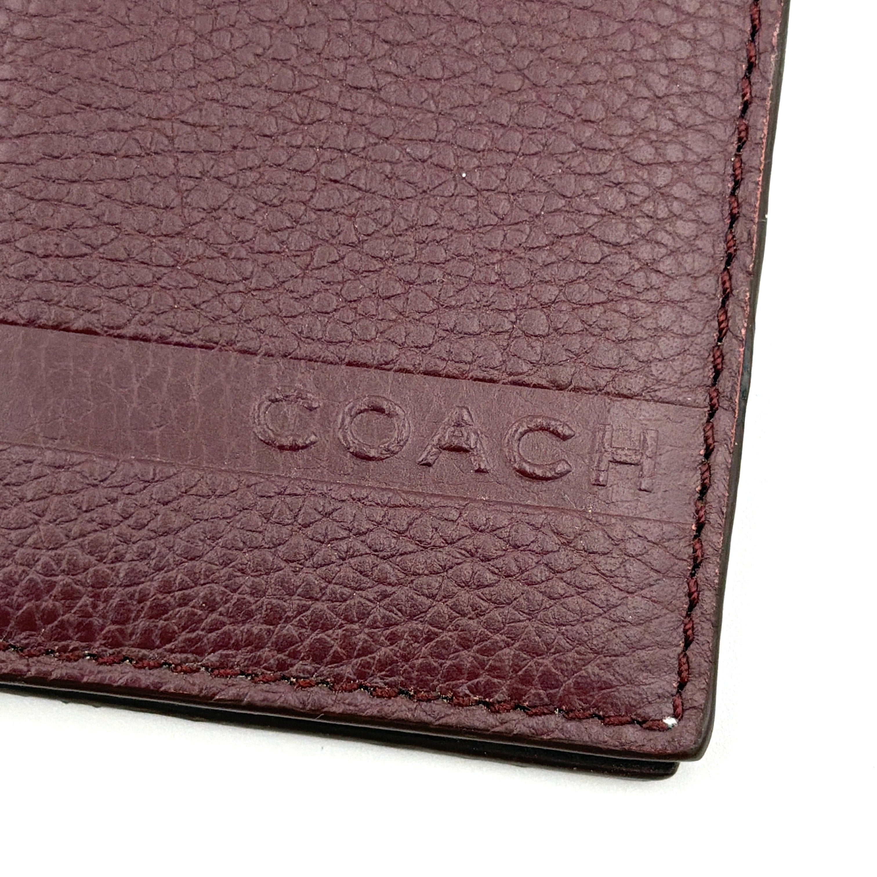 Coach Camden Slim Card Holder in burgundy pebbled leather with embossed logo and sleek bifold silhouette.