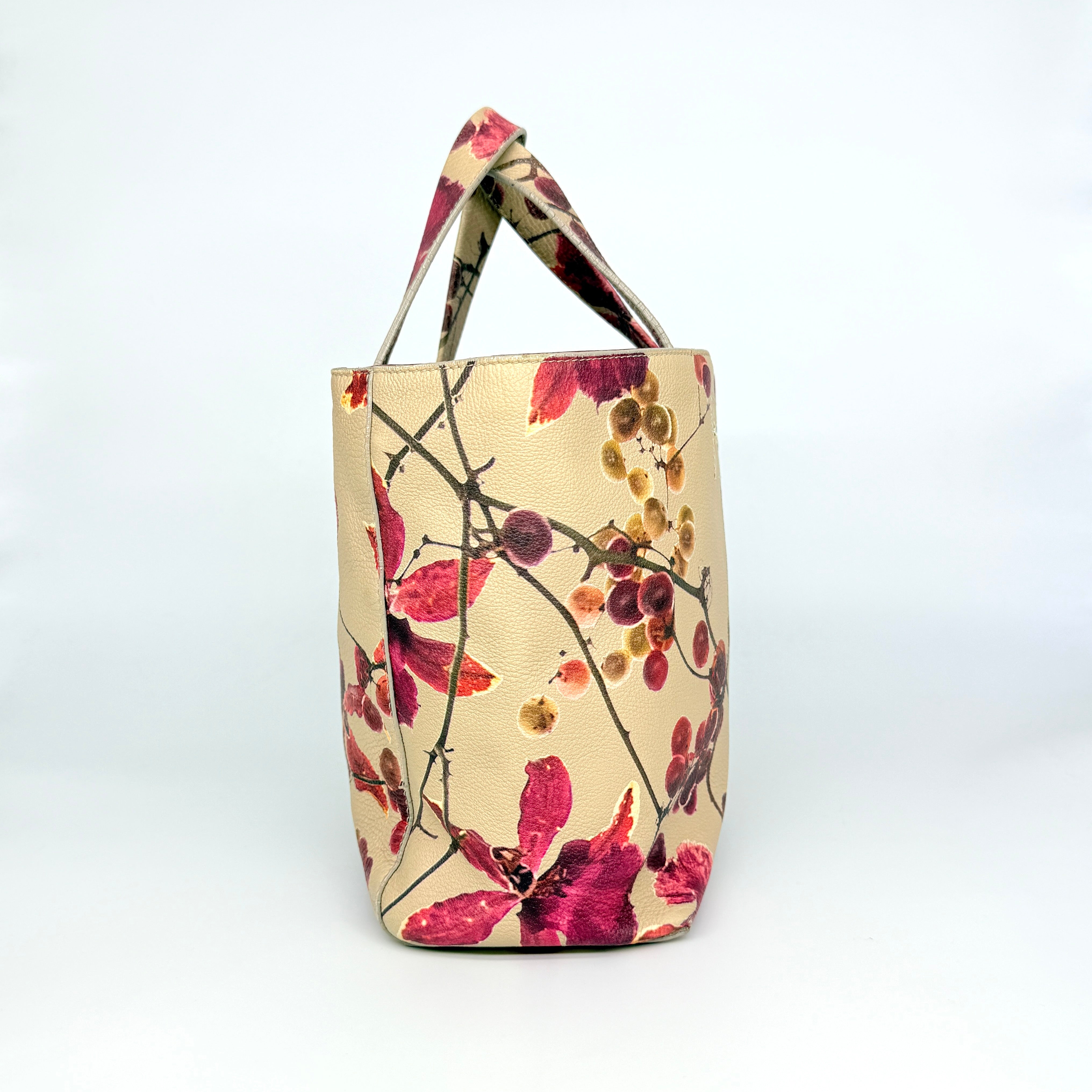 Furla beige leather tote bag adorned with a bold magenta and plum floral print, featuring structured short handles.