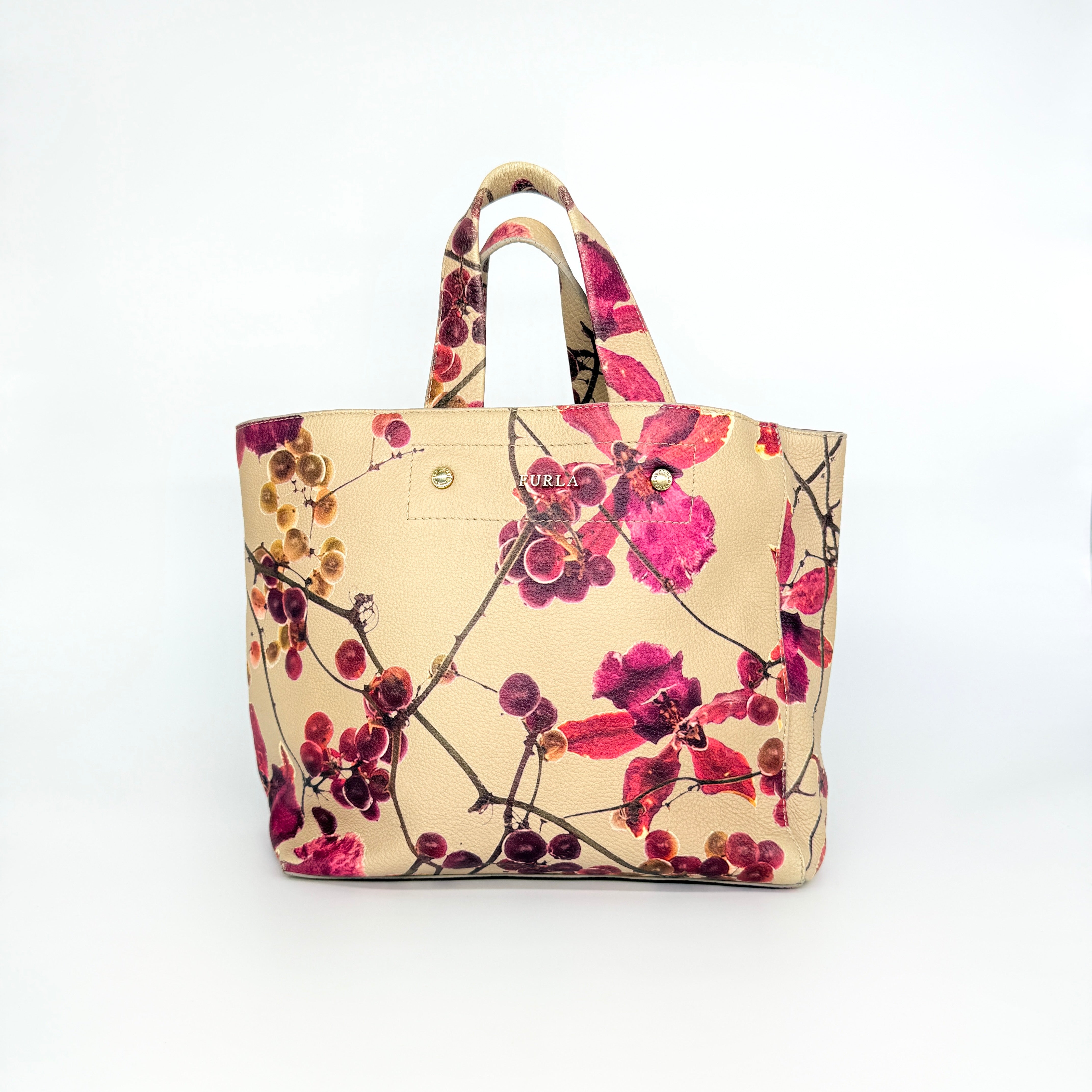 Furla beige leather tote bag adorned with a bold magenta and plum floral print, featuring structured short handles.