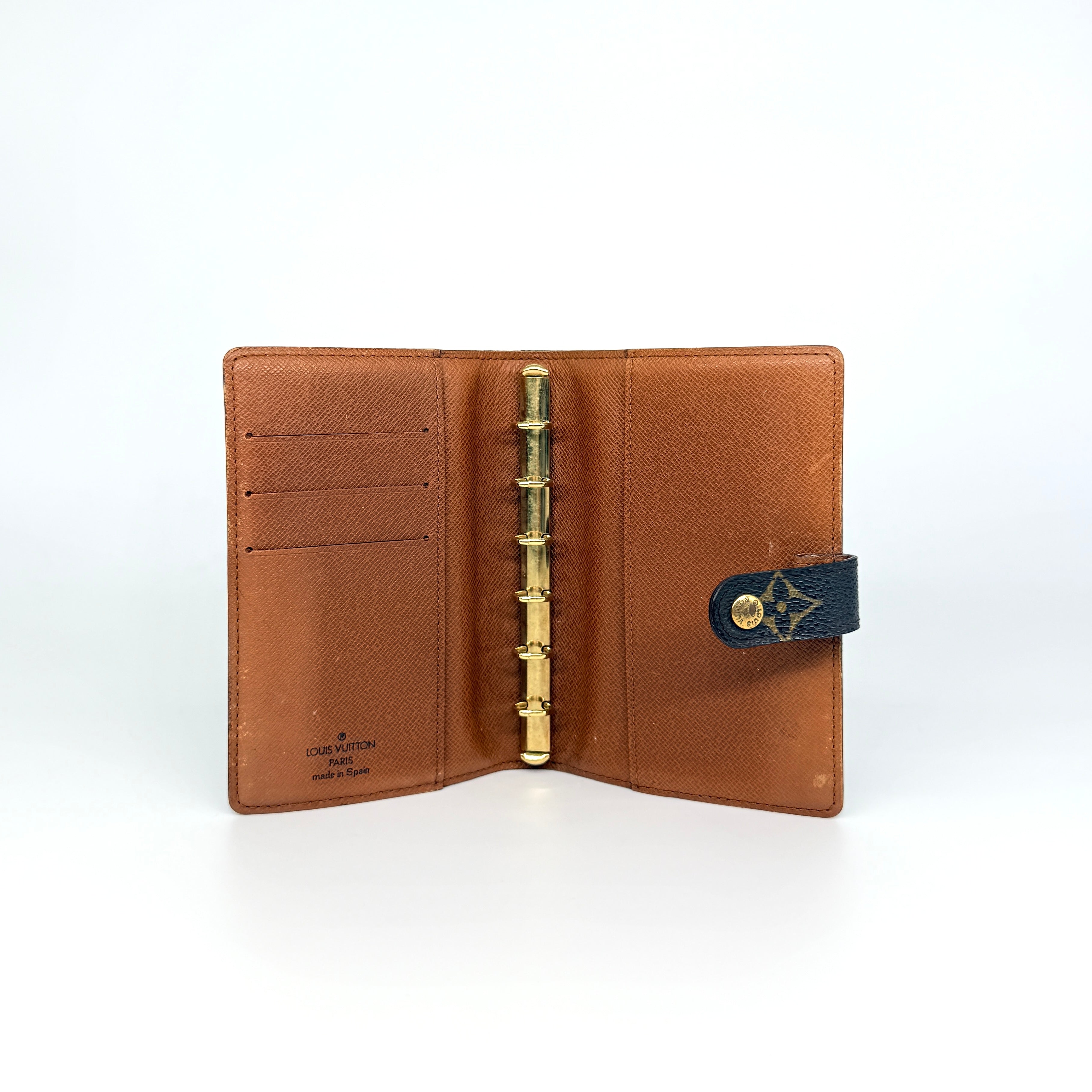 Louis Vuitton Monogram Agenda Cover in brown canvas with gold snap closure, displayed against a white background.