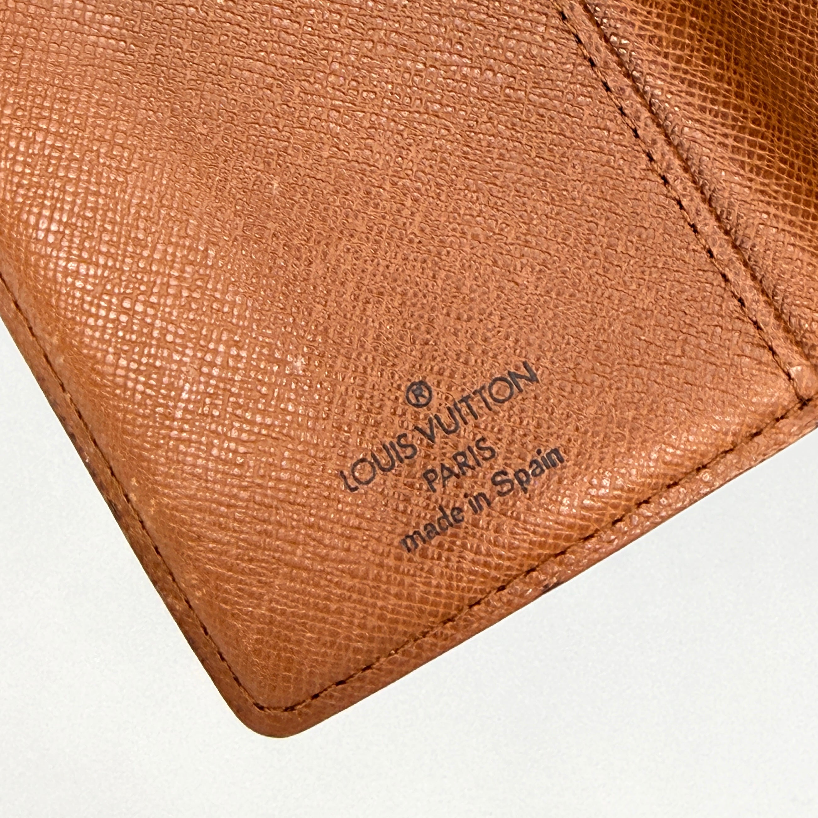 Louis Vuitton Monogram Agenda Cover in brown canvas with gold snap closure, displayed against a white background.