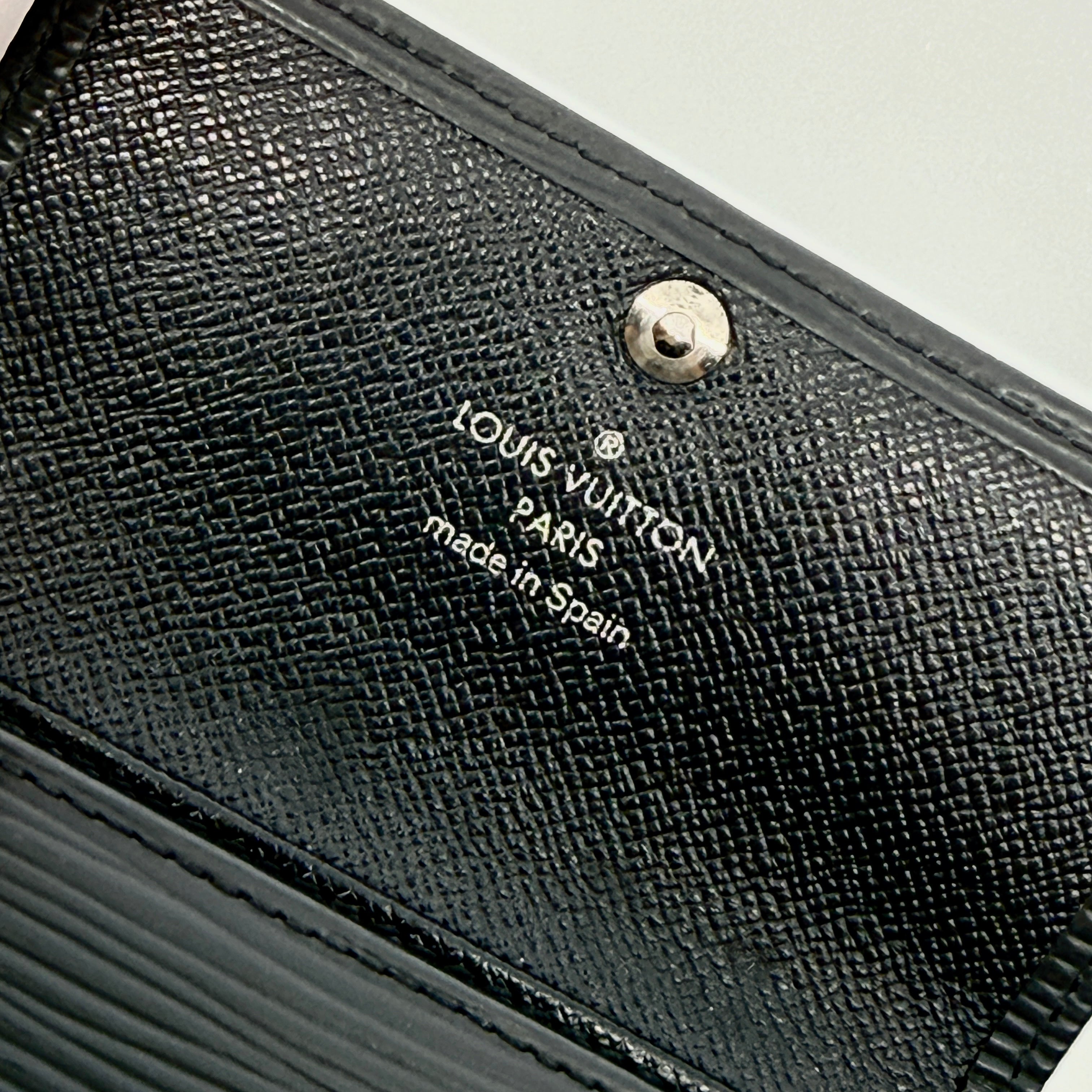 Louis Vuitton Epi Leather key case in black with silver-tone key hooks and snap closure, photographed against a clean white background.