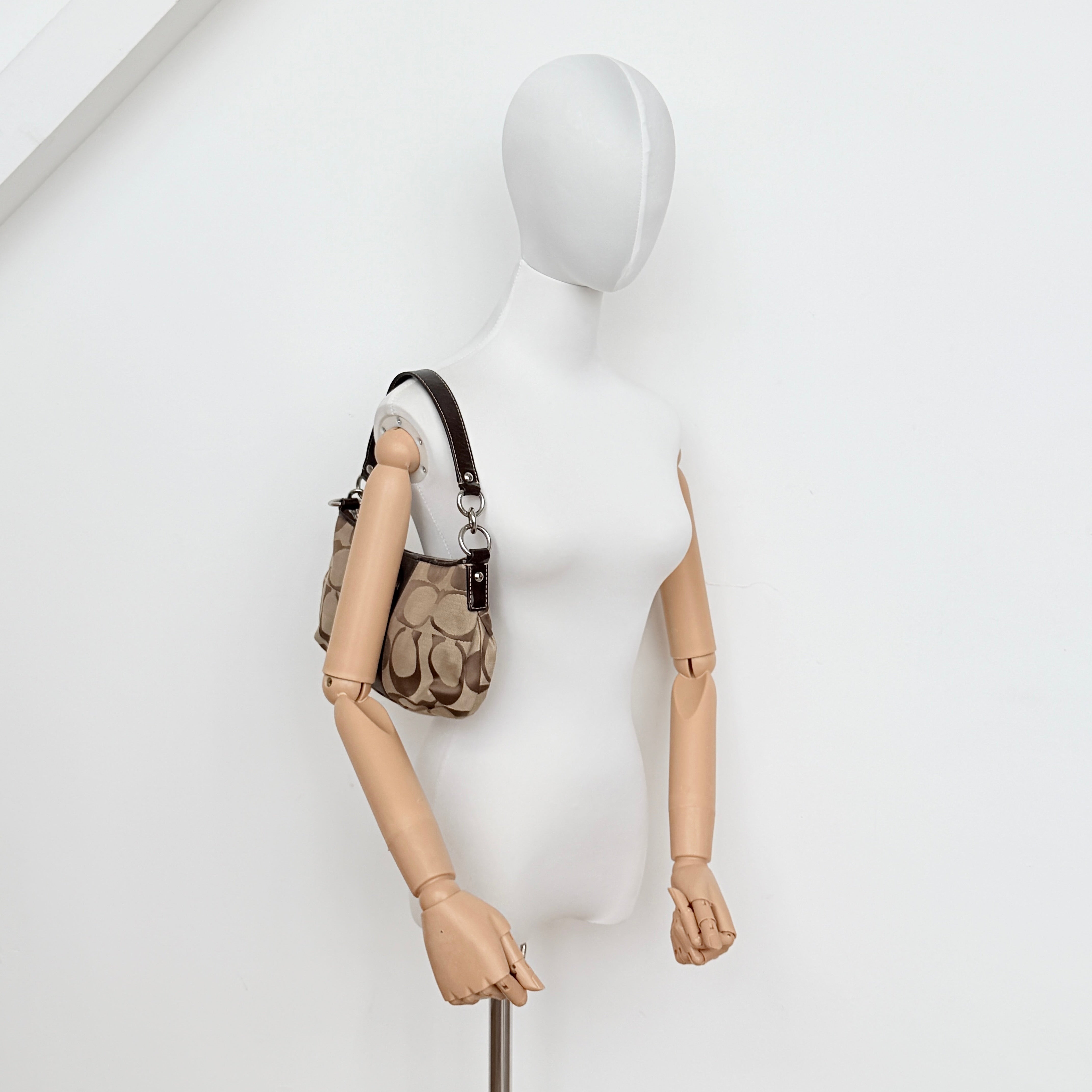 Coach beige and brown 2Way Signature Stripe shoulder bag with silver hardware, leather trim, and detachable straps.