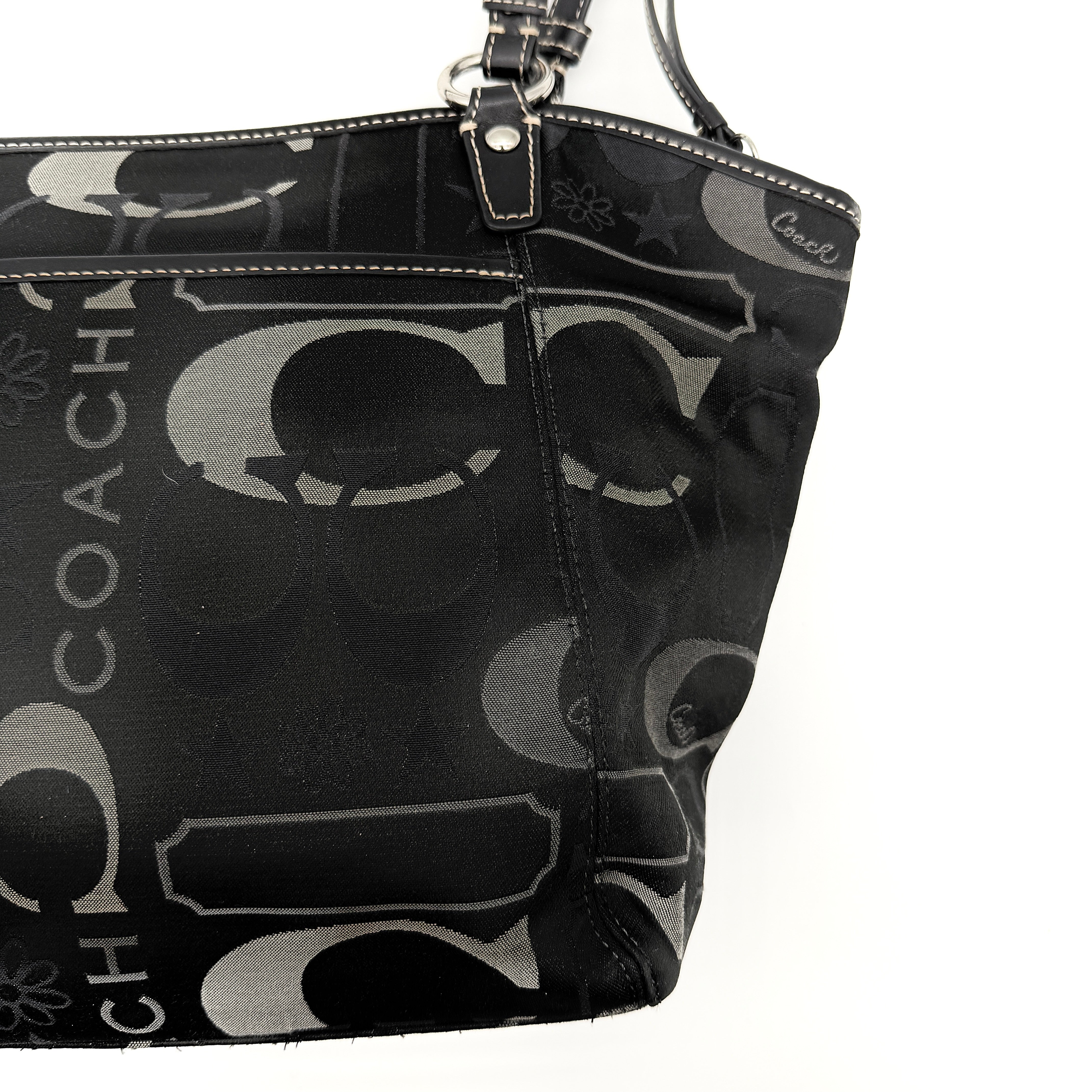 Coach Signature Leah Shoulder Bag in black jacquard with silver-tone hardware and bold logo pattern.