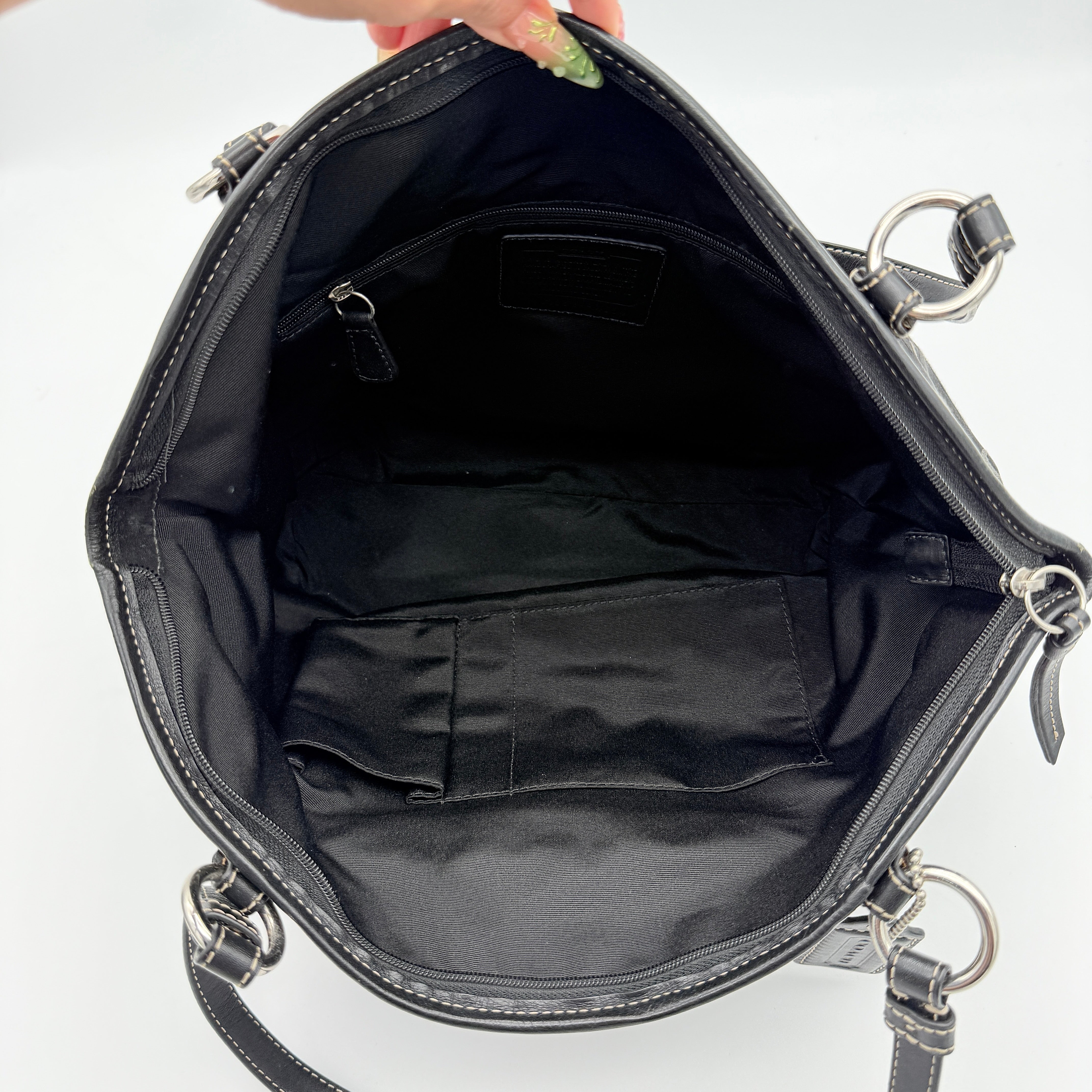Coach Signature Leah Shoulder Bag in black jacquard with silver-tone hardware and bold logo pattern.
