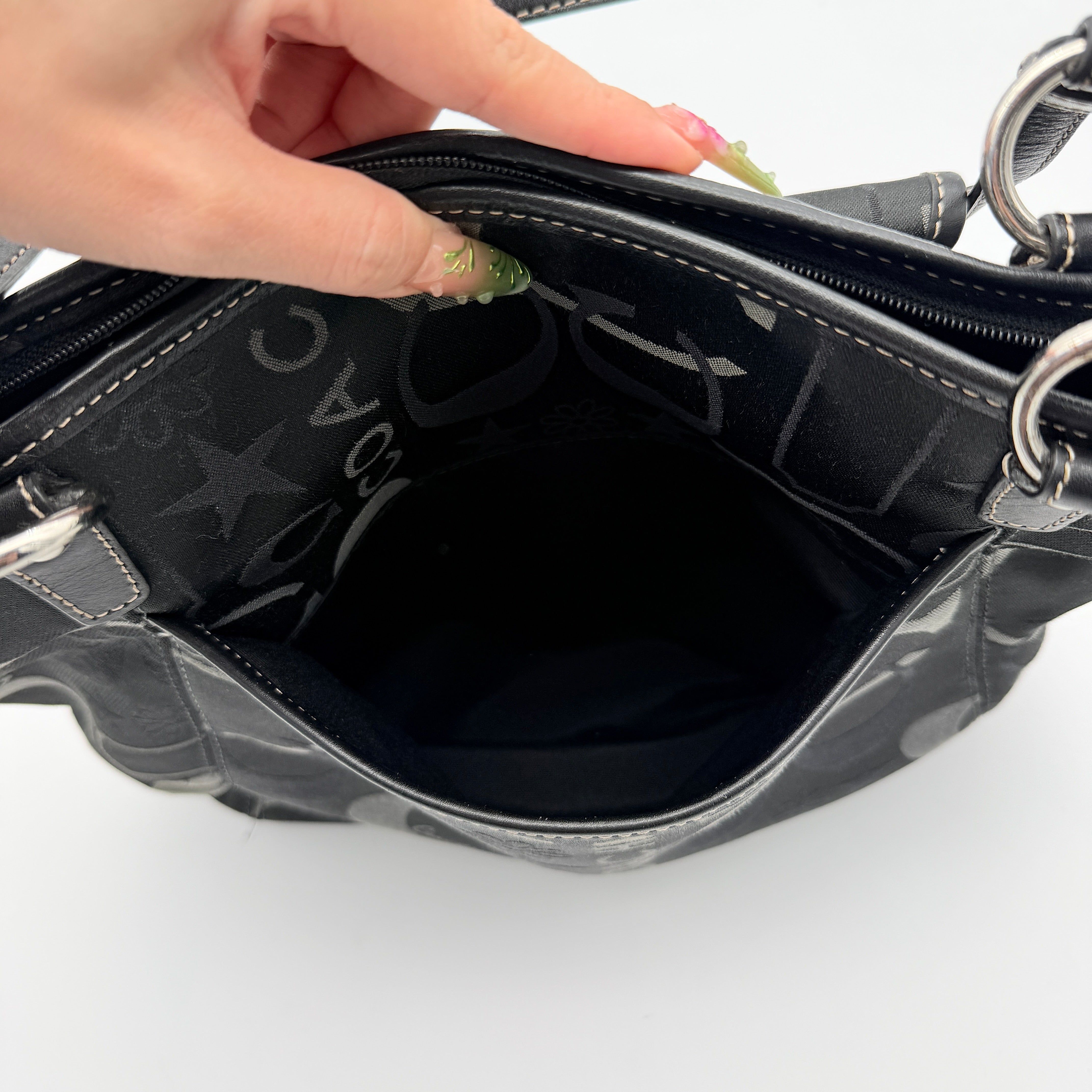 Coach Signature Leah Shoulder Bag in black jacquard with silver-tone hardware and bold logo pattern.