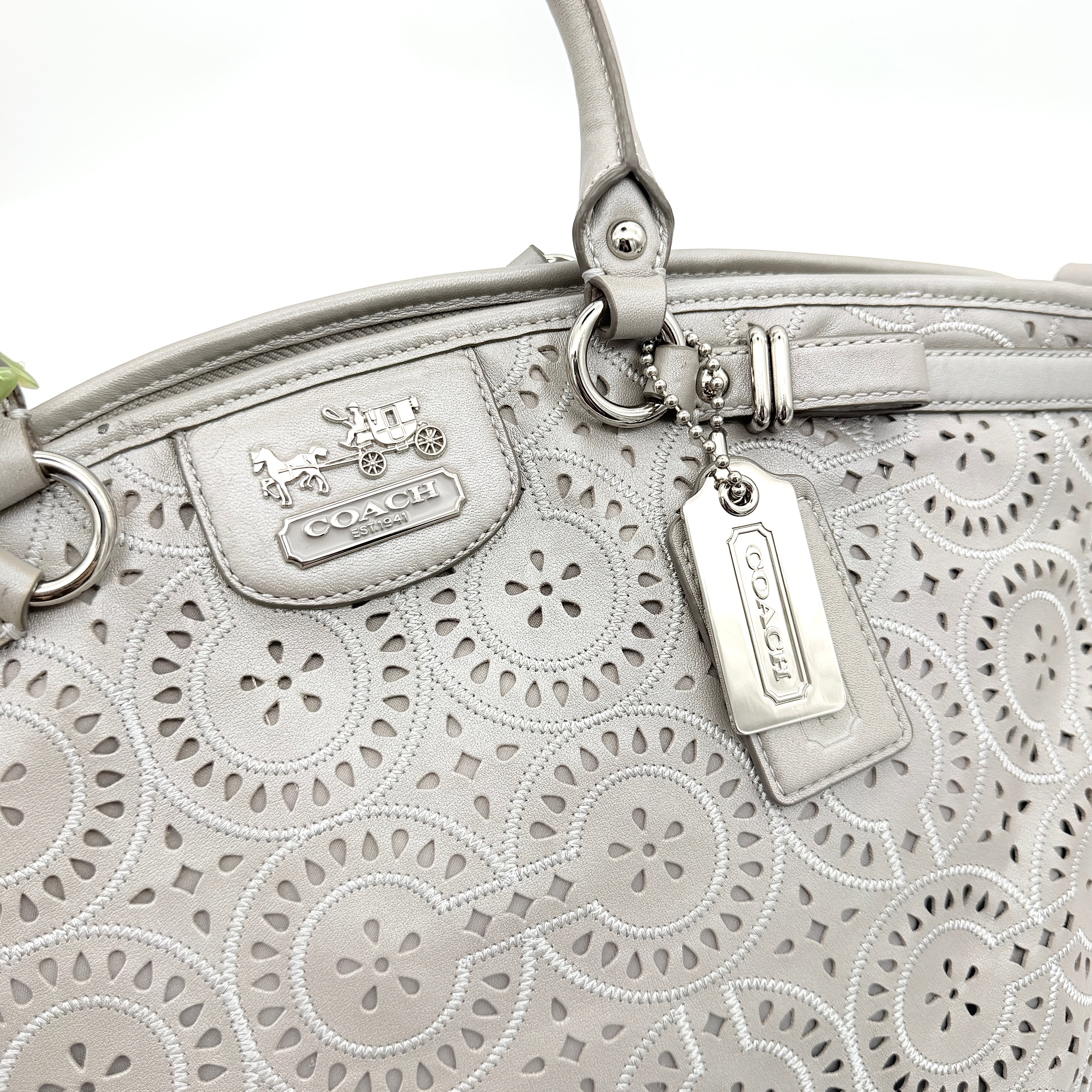Coach Madison Sophia Shoulder Bag in silver leather with intricate cutout details, shown with original dust bag and detachable strap.