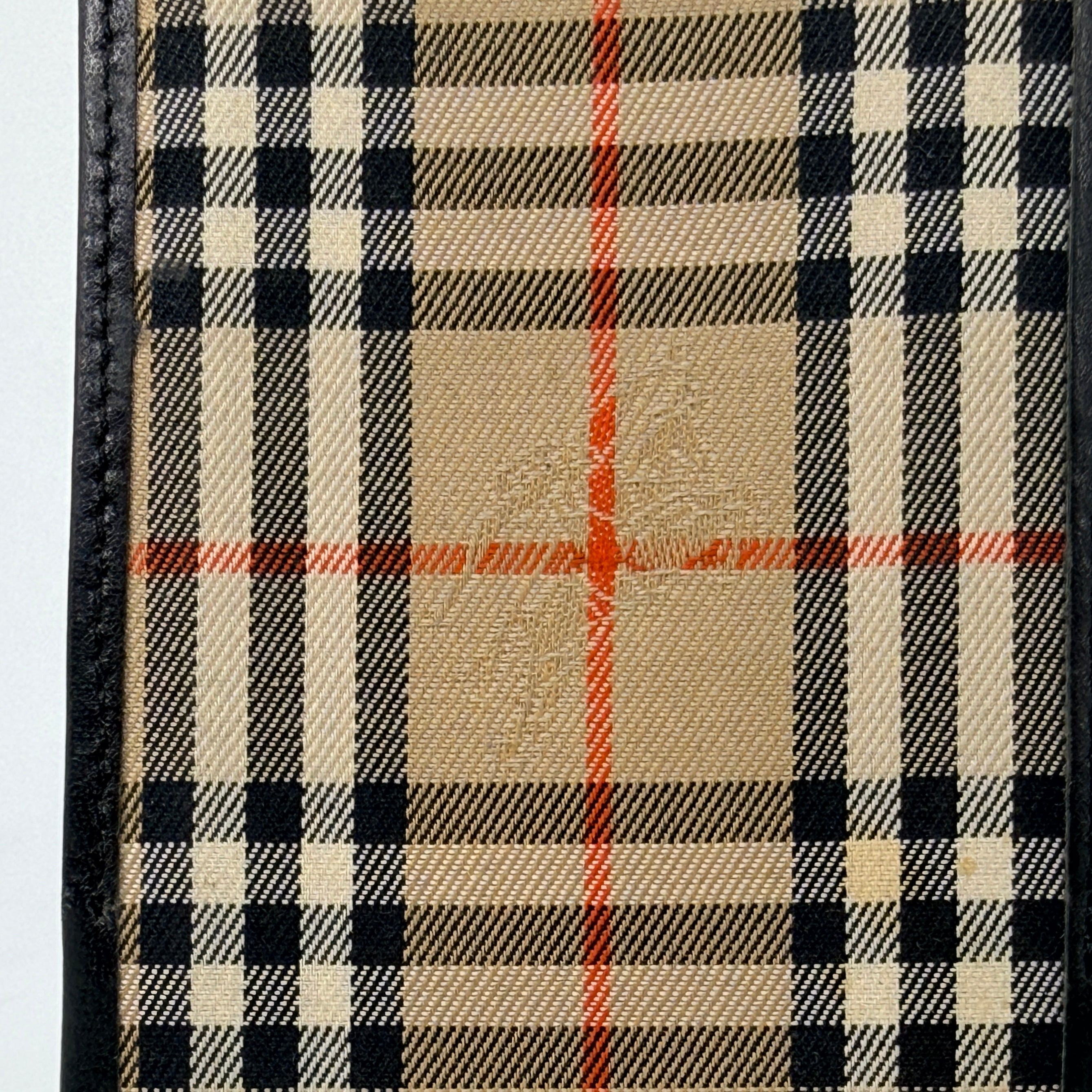 Front-facing view of a Burberry Nova Check cardholder in beige canvas with black leather trim and an oval Burberrys plaque.
