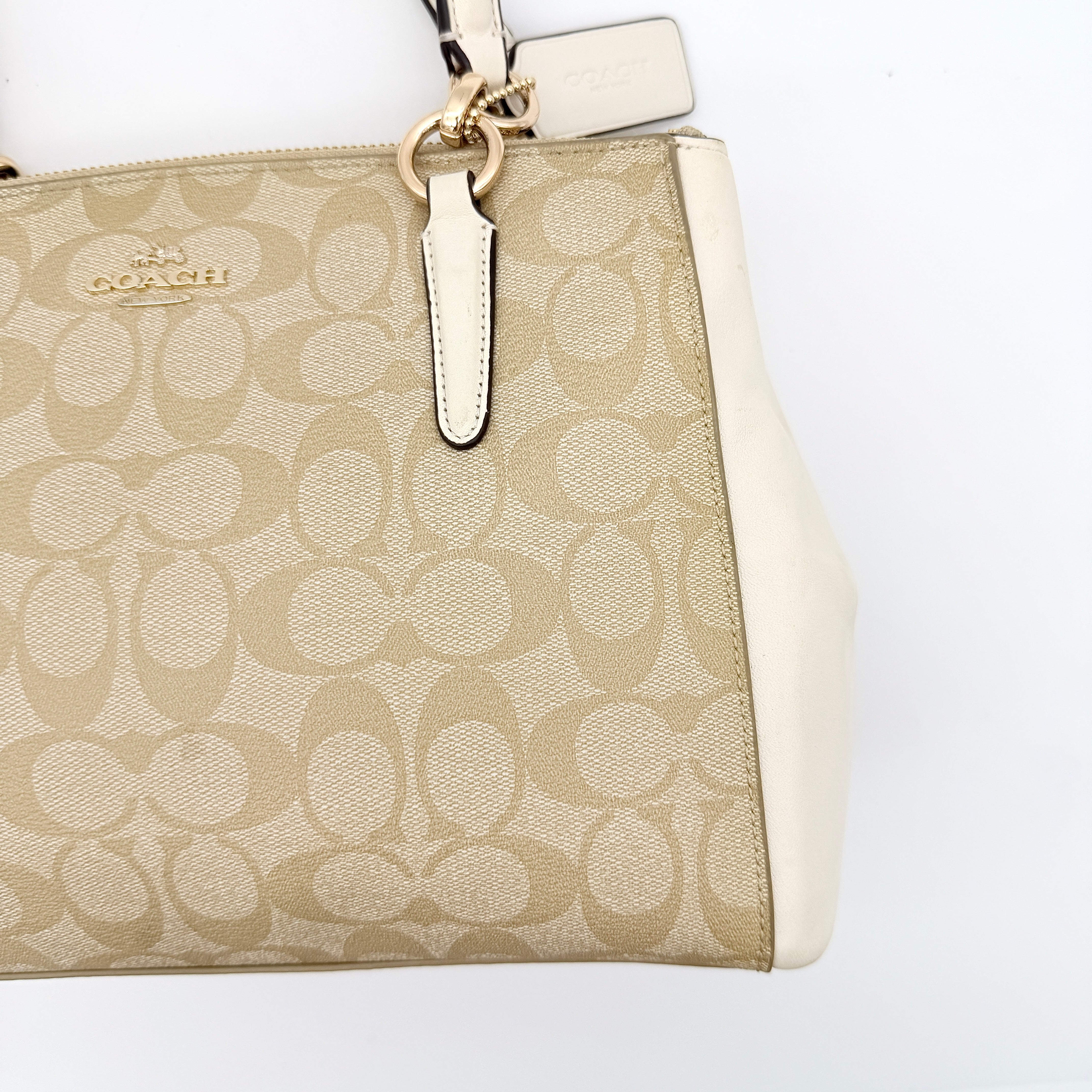 Coach Signature Christie Carryall in beige jacquard with white leather panels, double handles, and detachable strap.