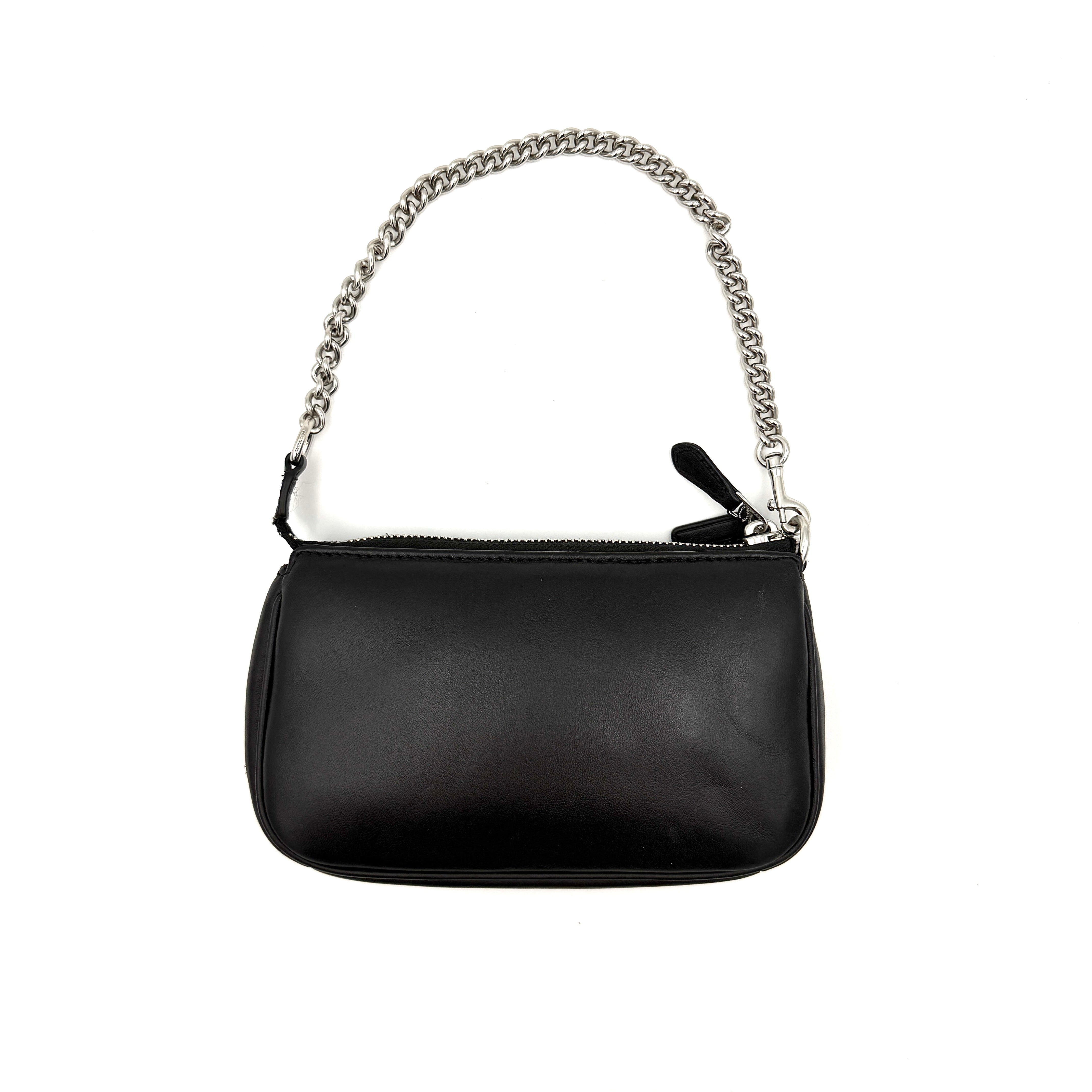 Coach Nolita 19 shoulder bag in quilted black leather with a bold stitched 'C' emblem and chunky silver chain strap.