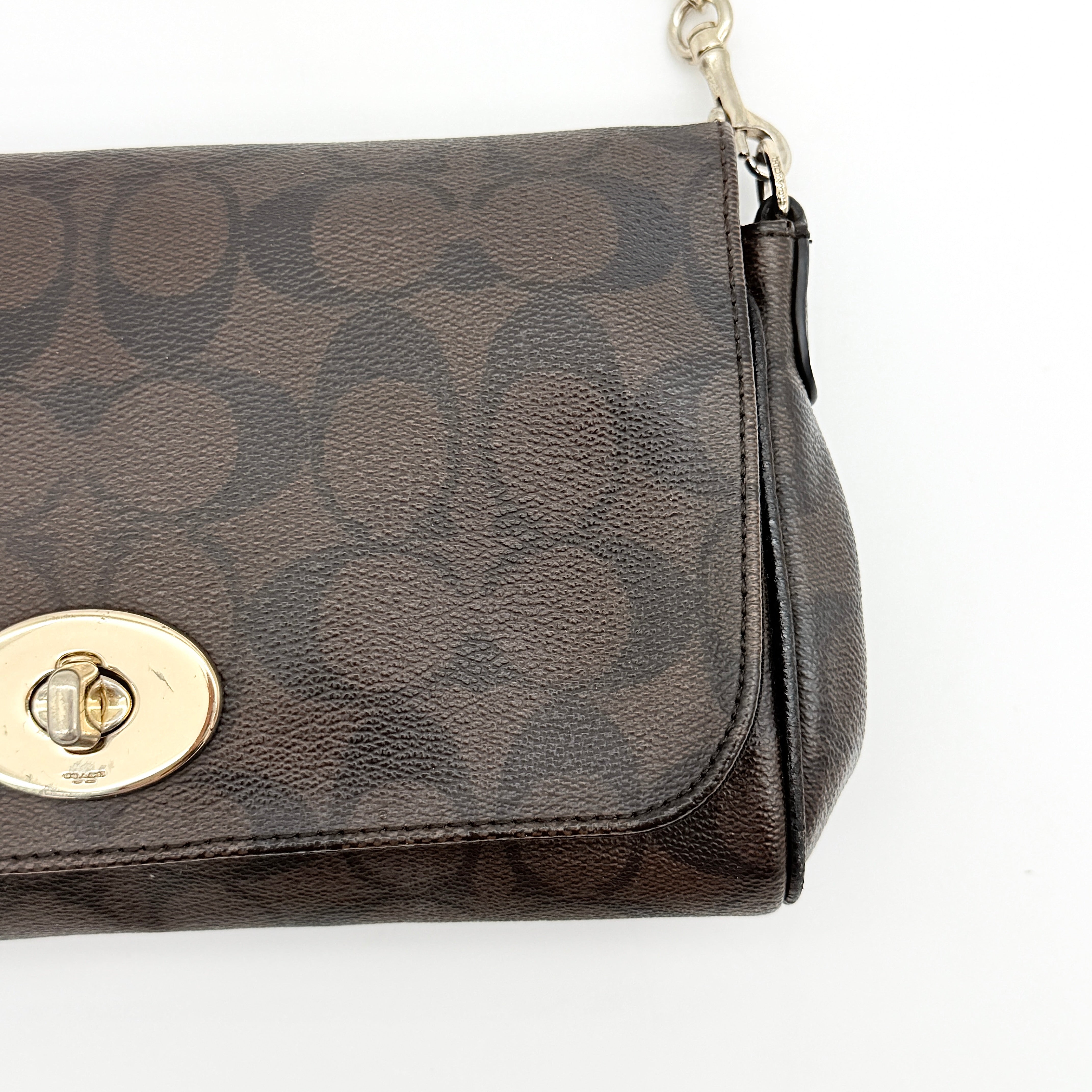 Coach Signature Ruby shoulder bag in brown and black with gold chain strap and detachable leather crossbody strap, displayed on a white background.