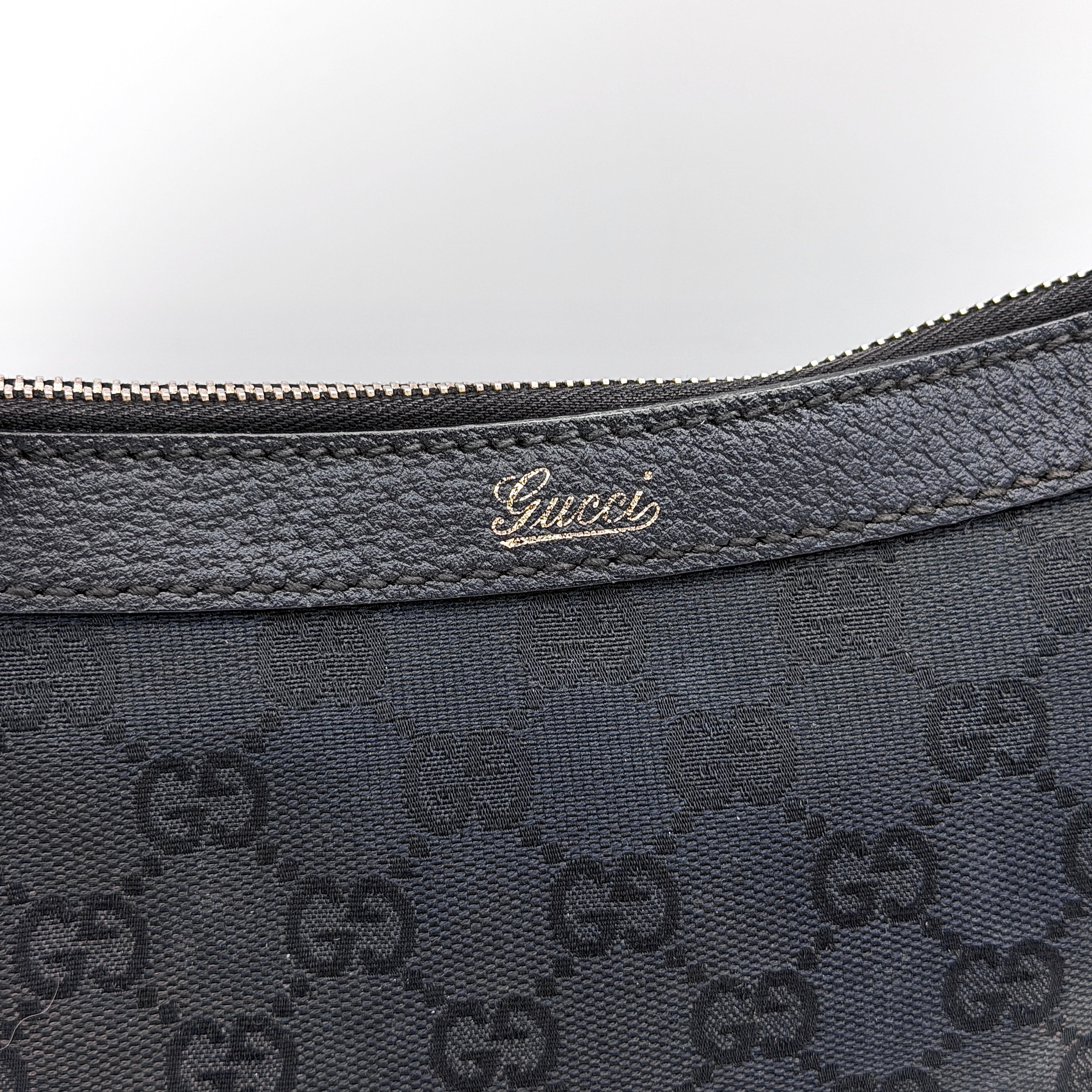 Front view of the Gucci GG Monogram Abbey Shoulder Bag in black with curved handle and gold hardware.