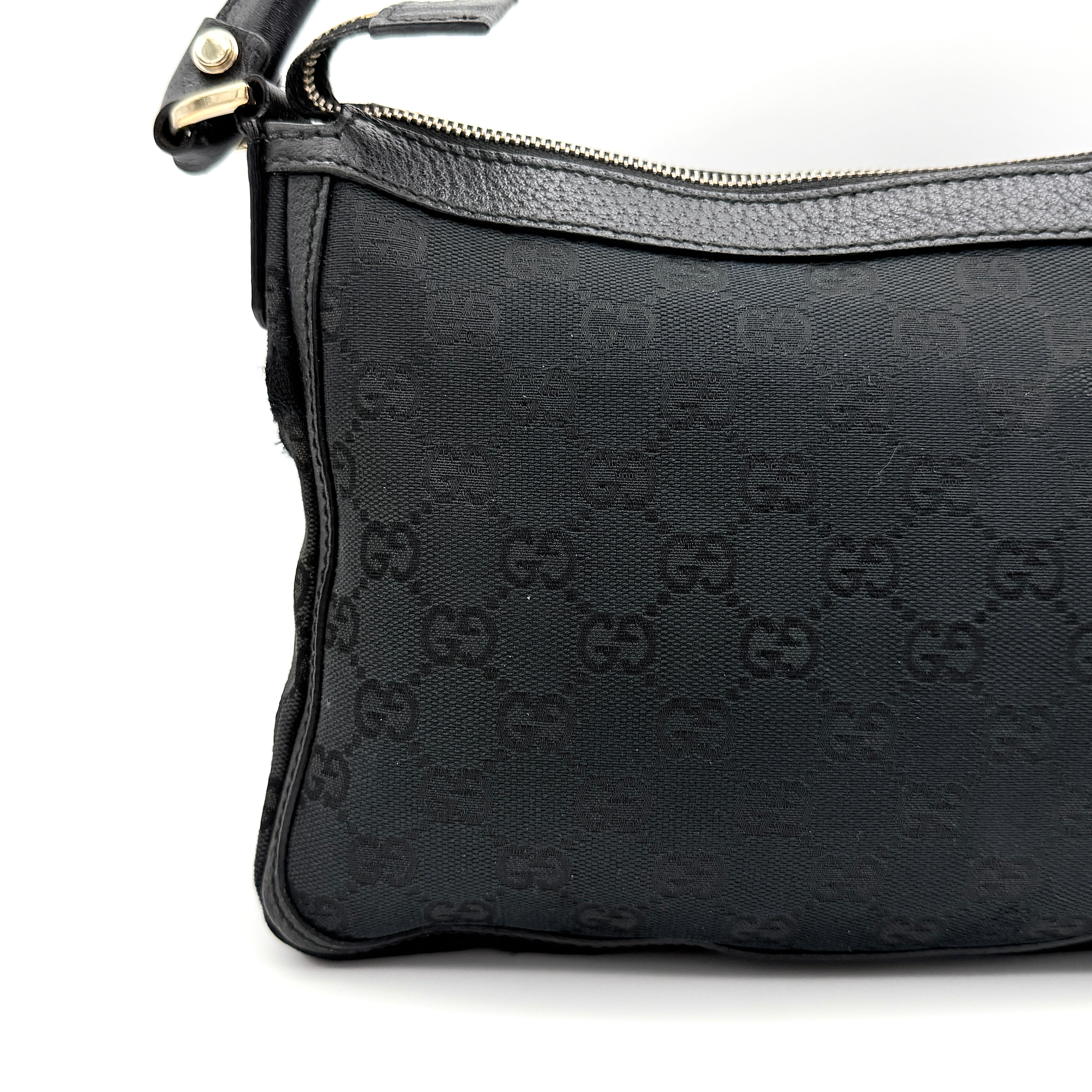 Front view of the Gucci GG Monogram Abbey Shoulder Bag in black with curved handle and gold hardware.