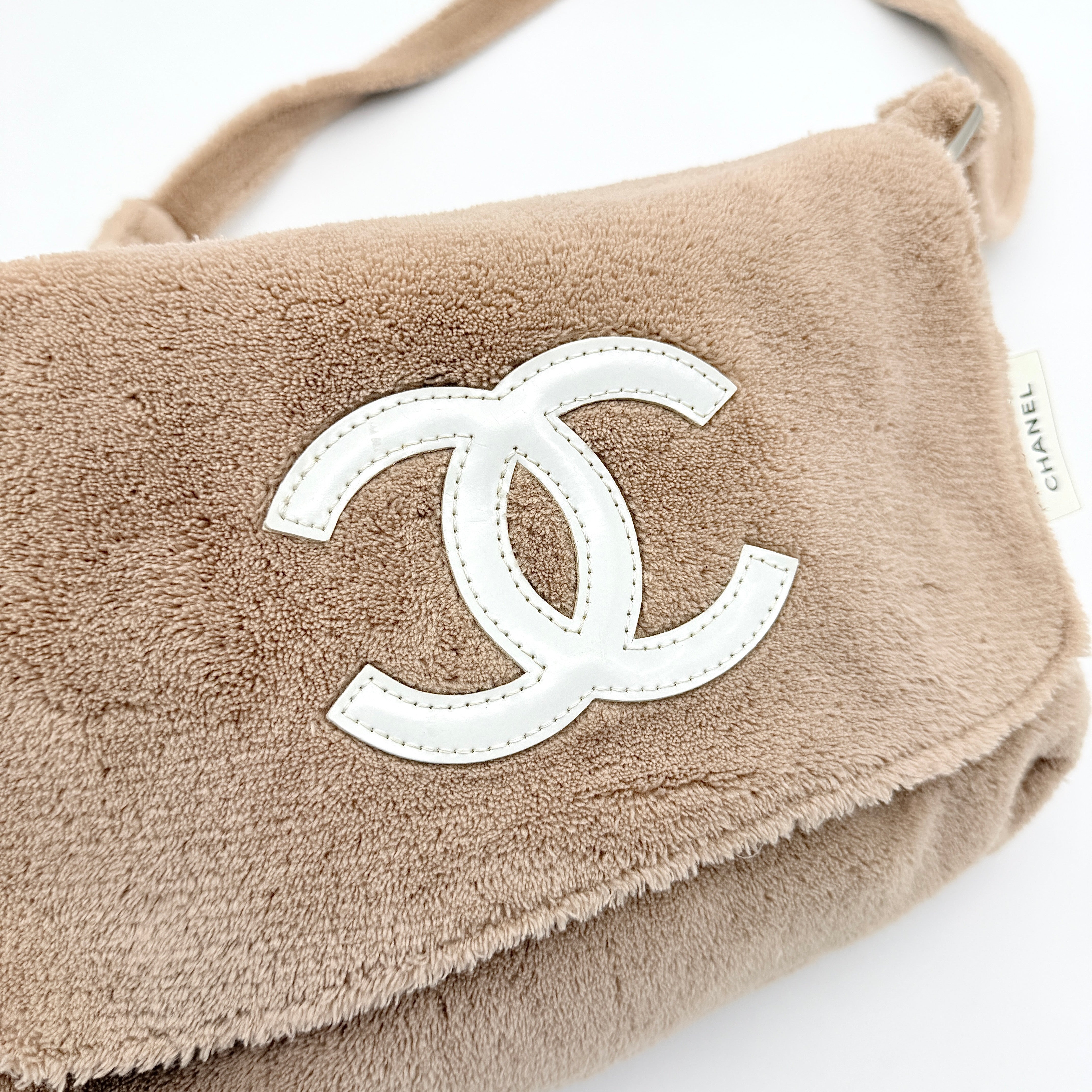 Chanel CC Precision Fragrance Line crossbody bag in beige terry cloth with white logo, shown with long strap.