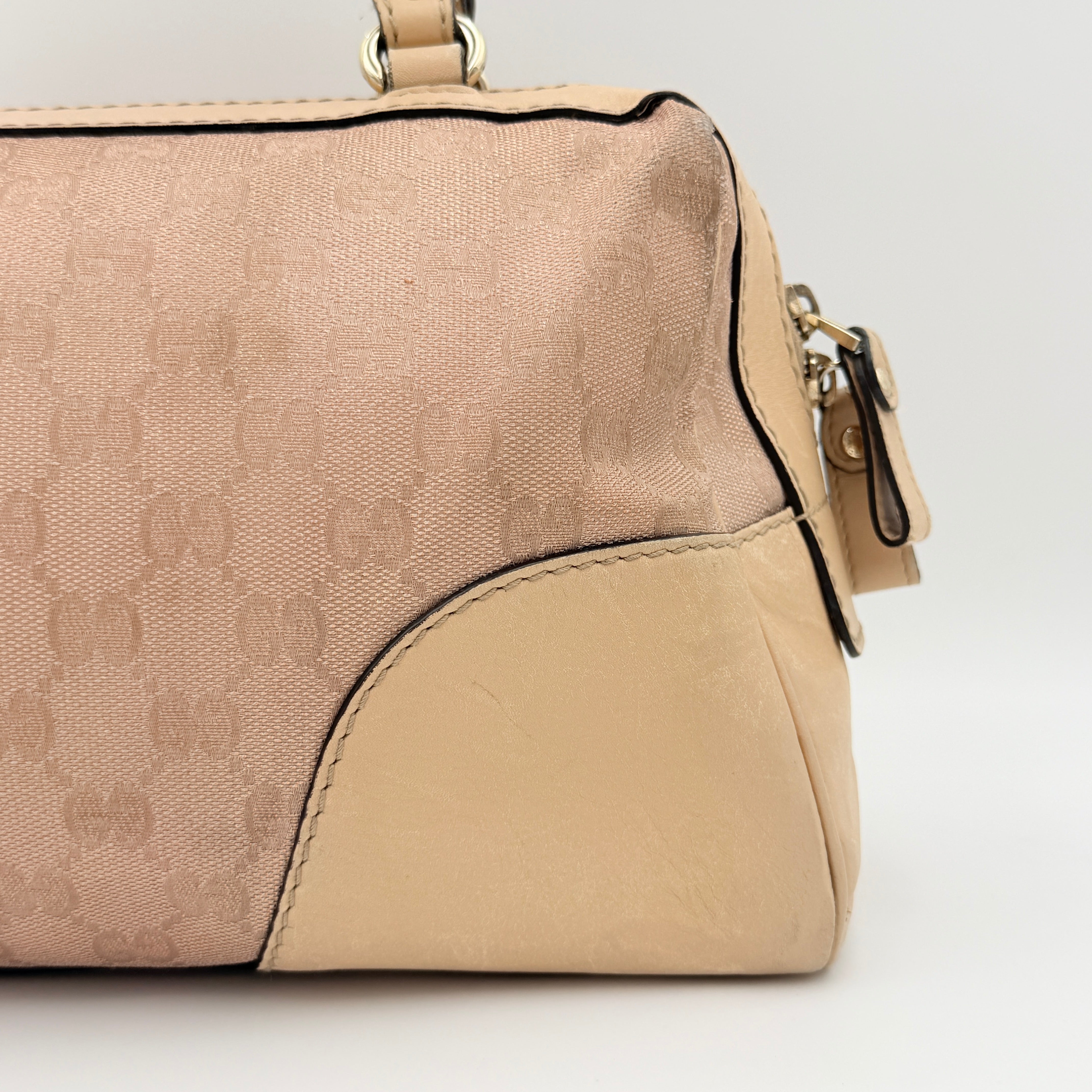 Gucci GG Monogram Heart Lovely Boston Bag in beige and pink with gold heart logo and double handles, displayed against a plain background.